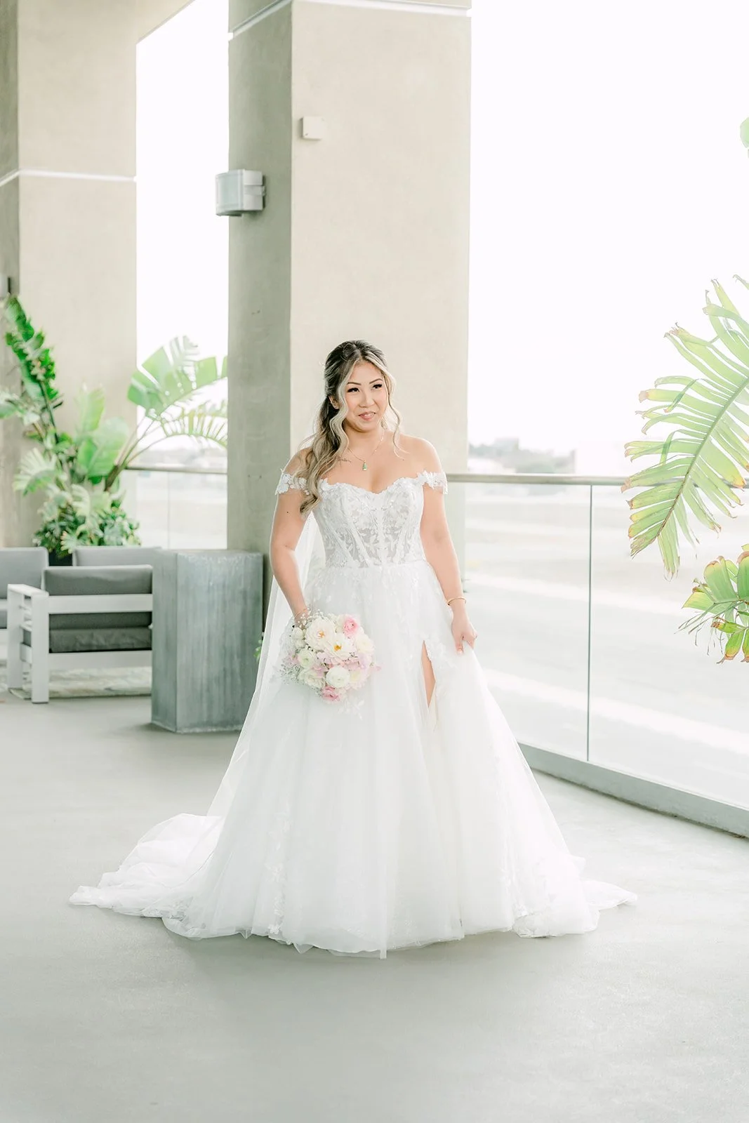 Bride walking toward the groom on the covered balcony above the airport