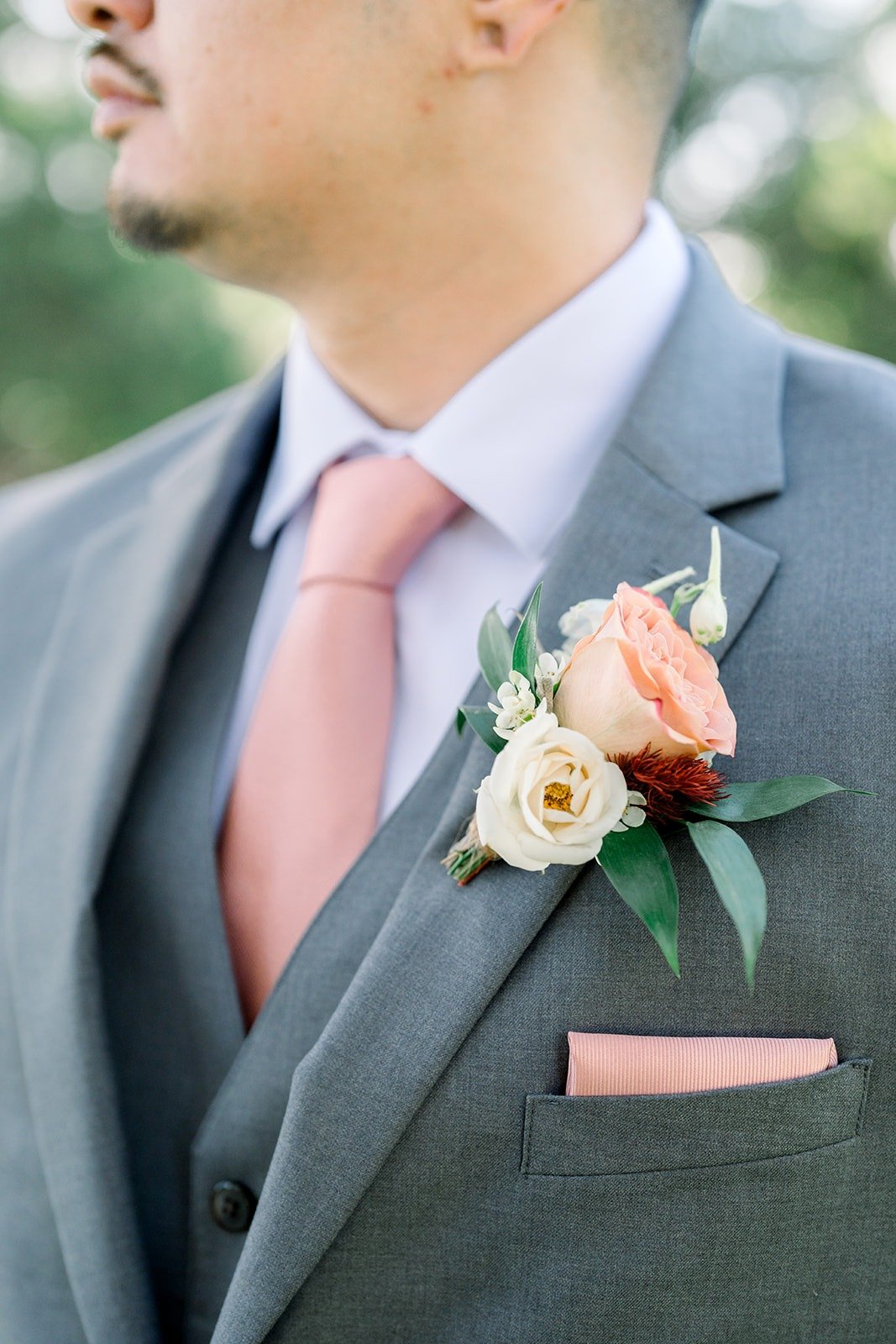 Close up of Mikey's peach rose boutonniere and pink pocket square