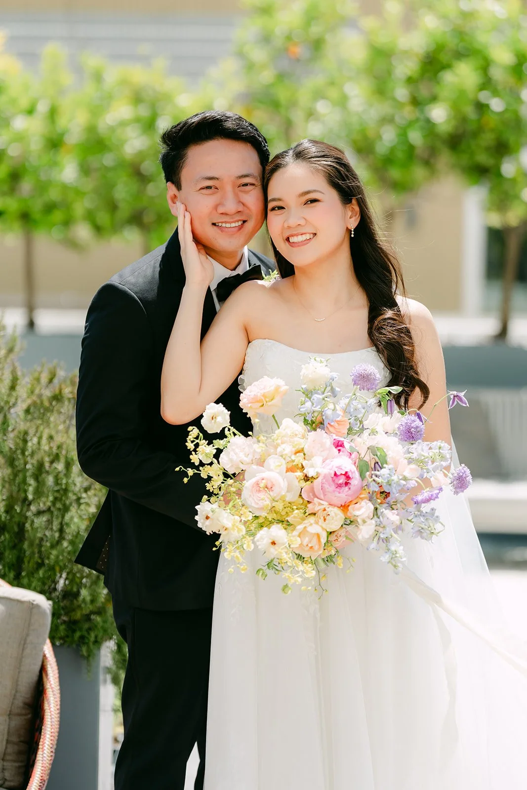 Hoan resting his chin on Linh's shoulder as she smiles