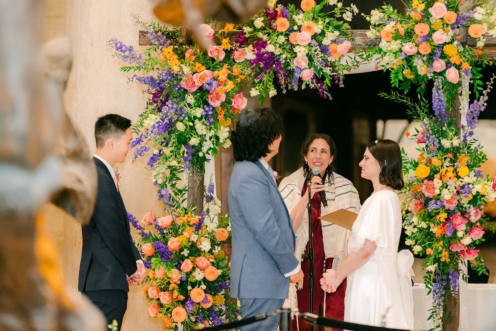 Jessie and Philip under the floral arch beside the dinosaurs