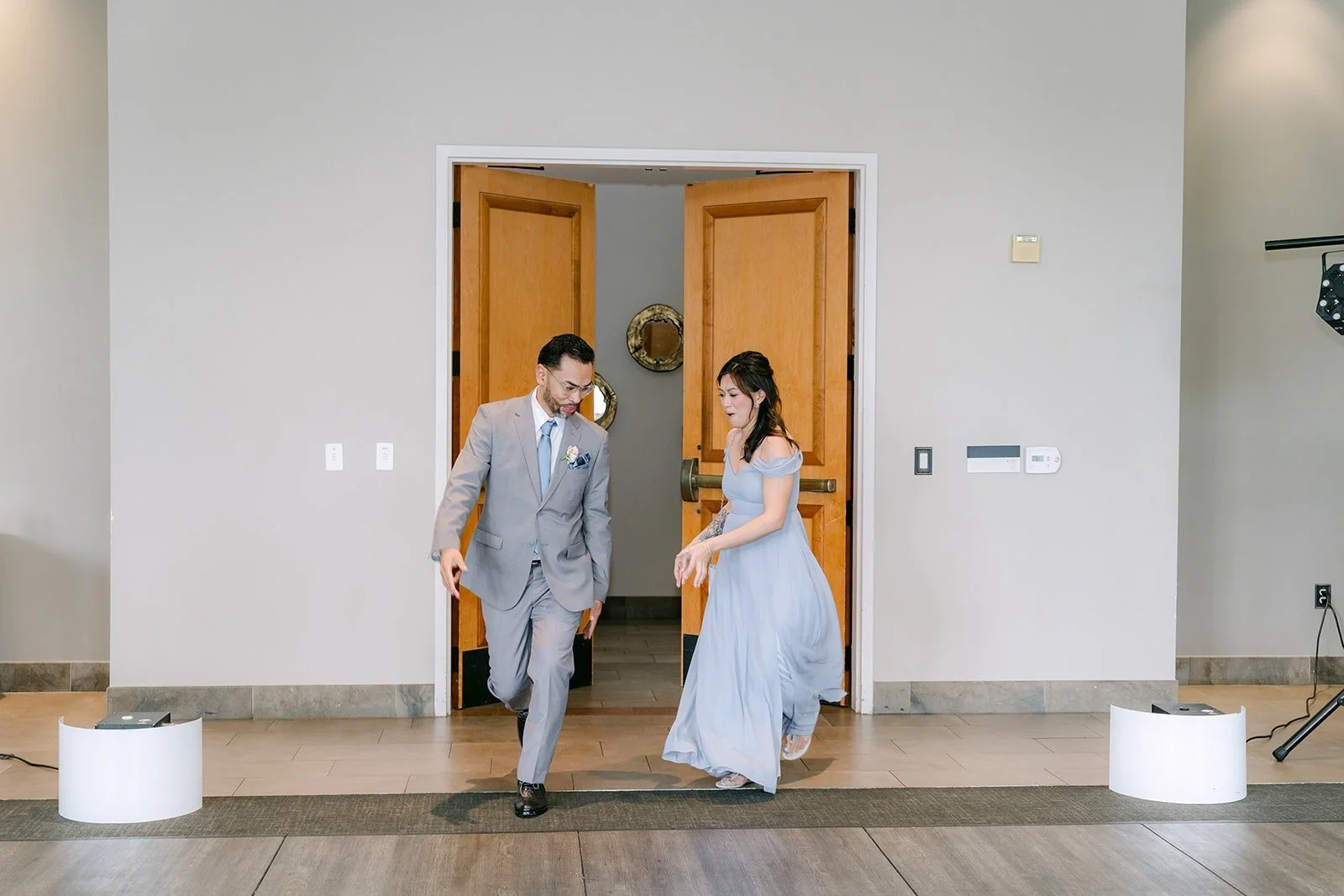 A groomsman and bridesmaid bursting through the doors for the grand entrance