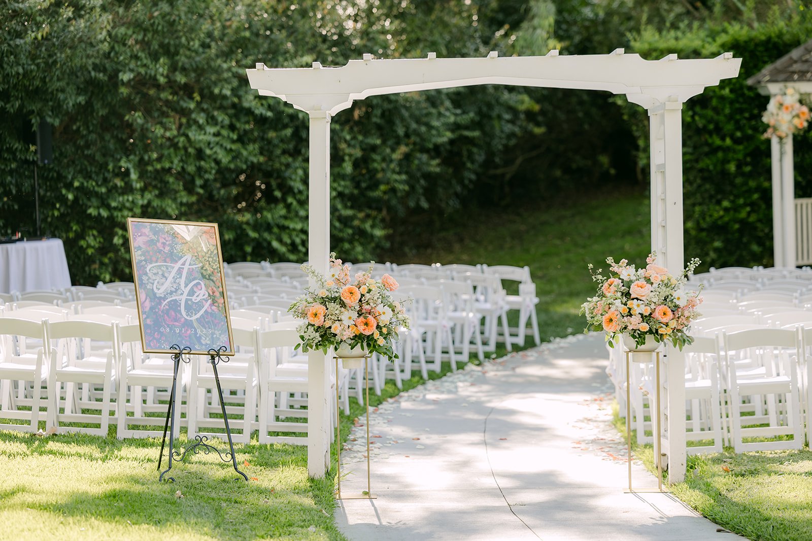 White pergola and chairs set for the ceremony