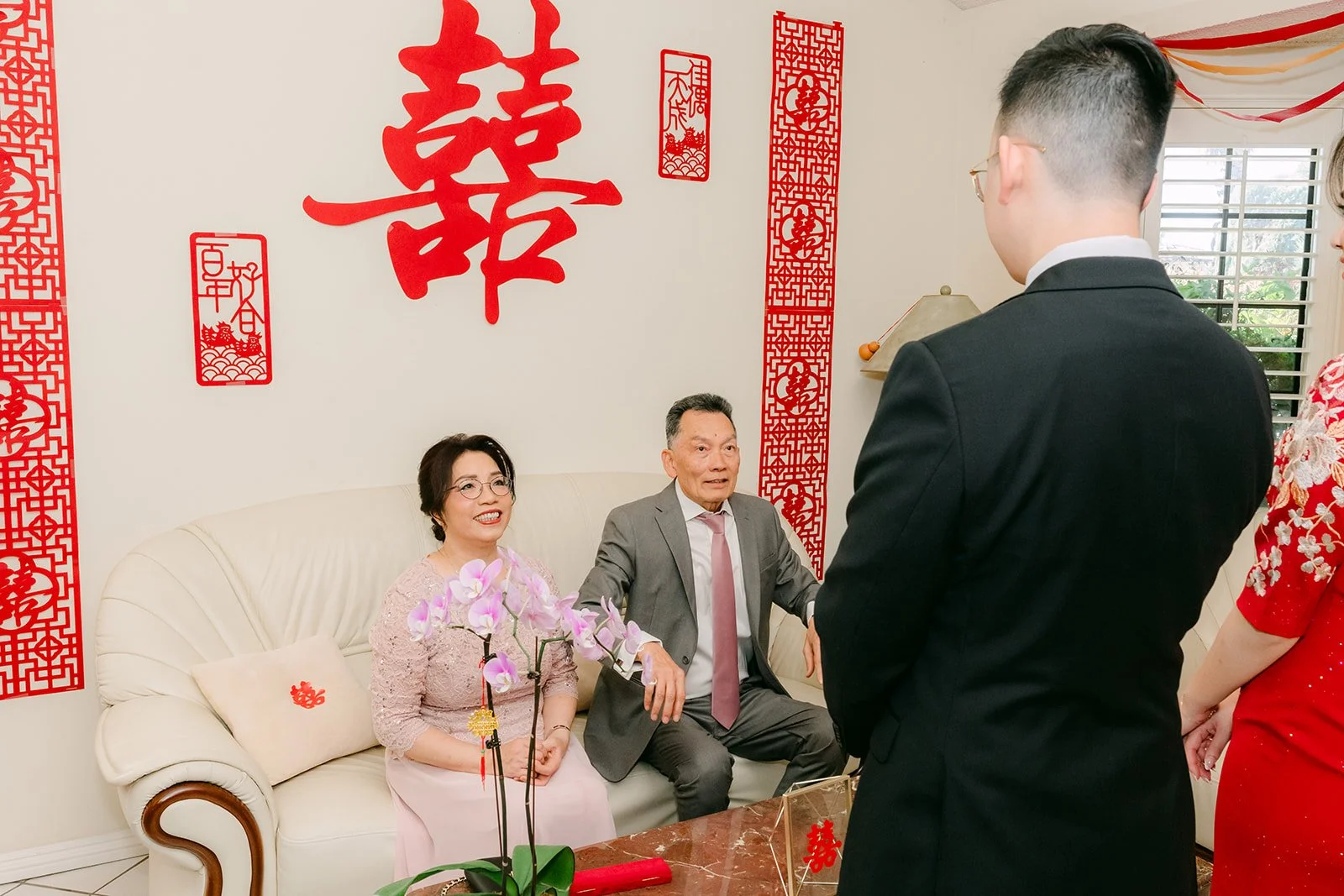 Ken bowing as he serves tea to Pauline's parents.