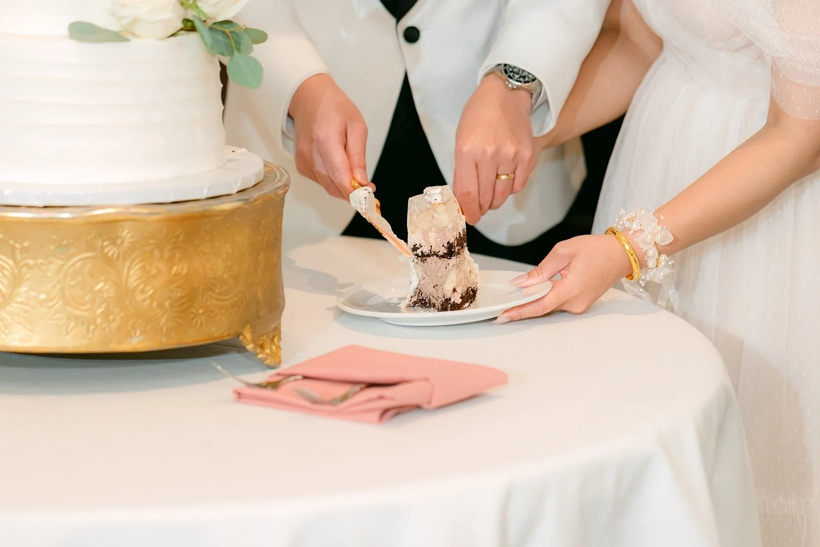 Ivy and Chungman slicing into their white cake