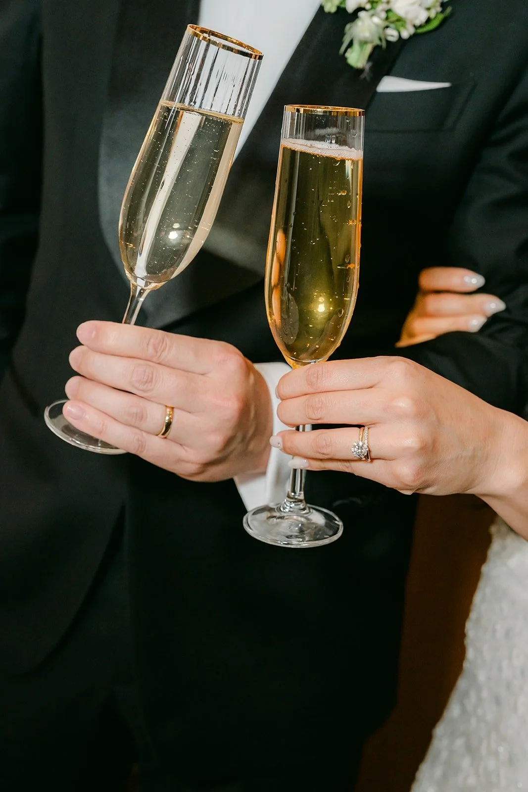 Champagne flutes raised for a toast at the cake table