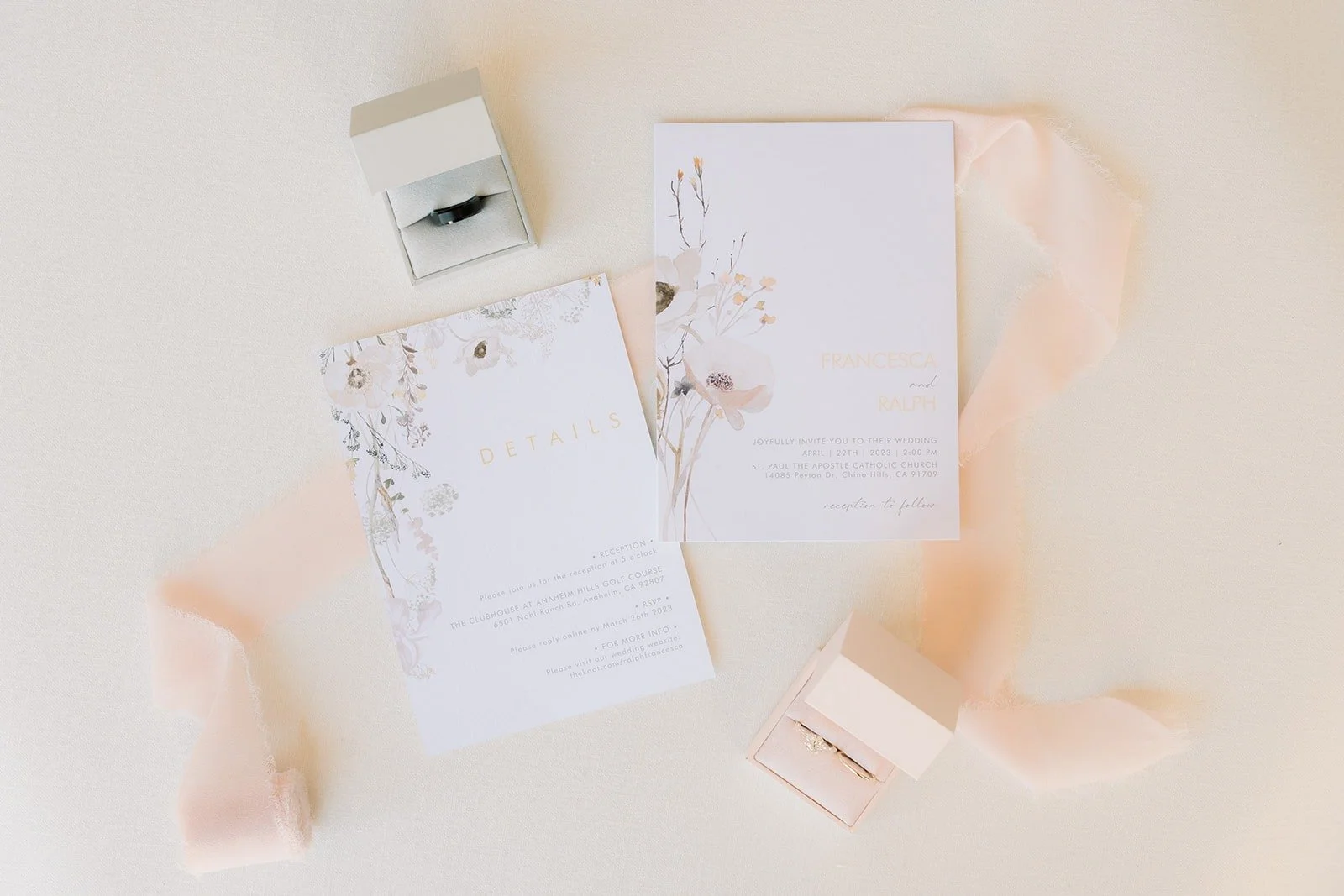Francesca and Ralph's invitation suite laid flat with blush ribbon and dried florals