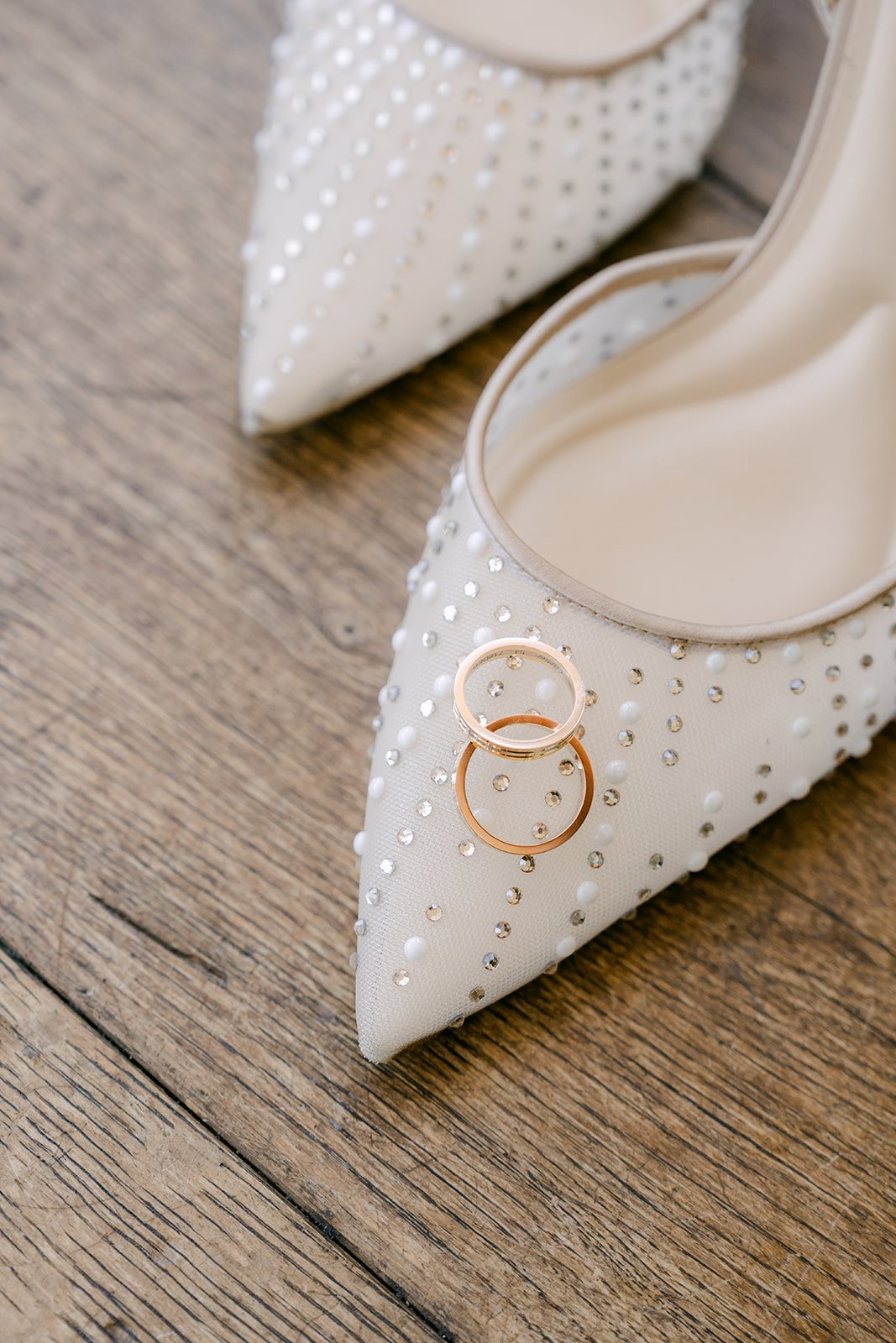 Wedding rings resting on Judy's lace heels