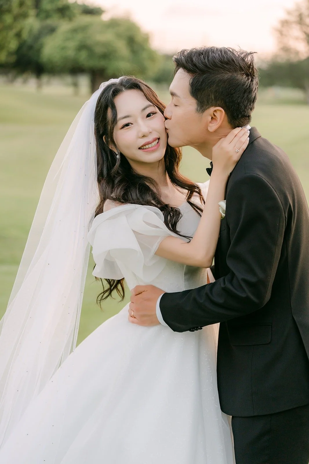 Eunsang kissing Jeannie's cheek on the fairway