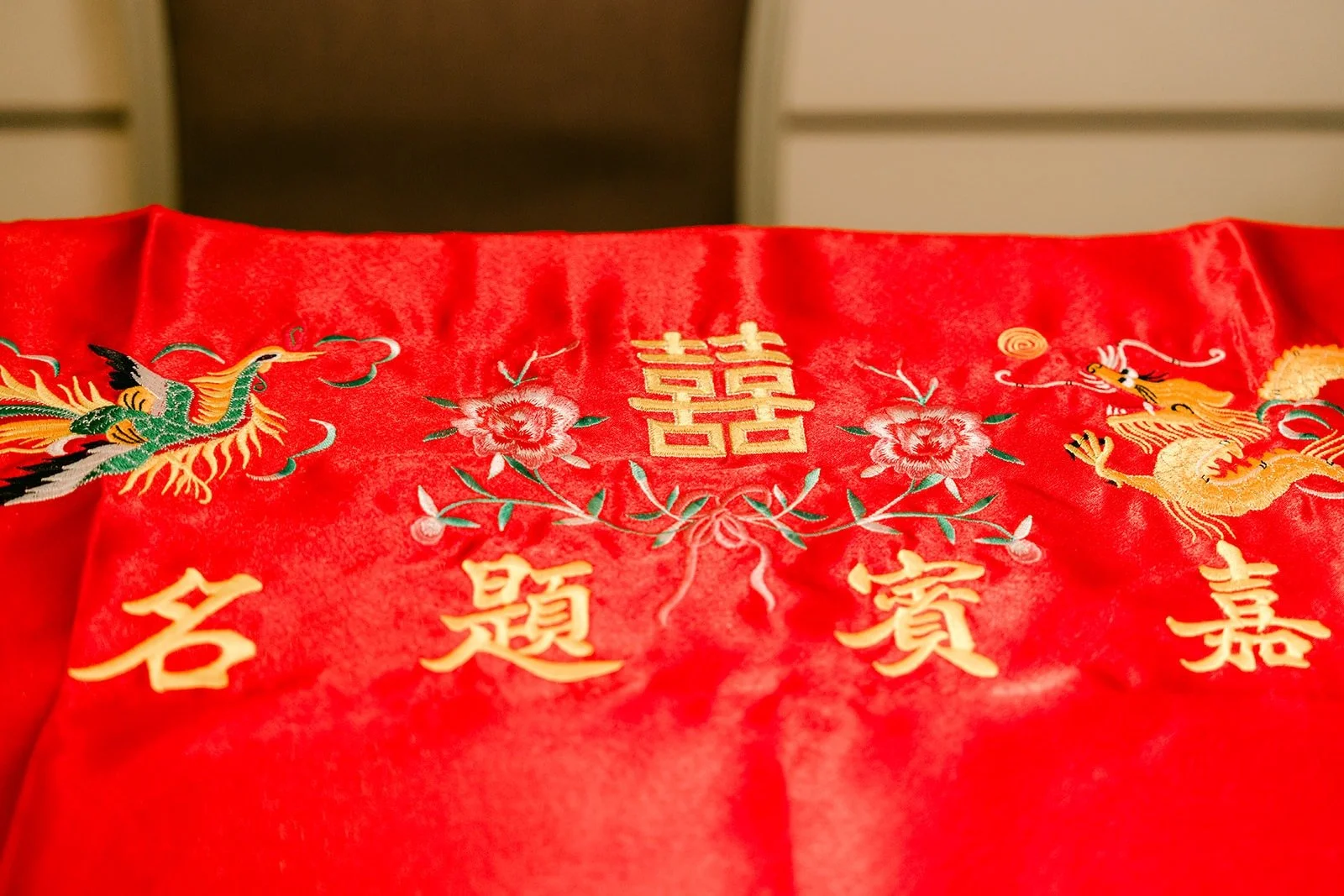 A red guest signing cloth embroidered with gold Chinese characters and dragons