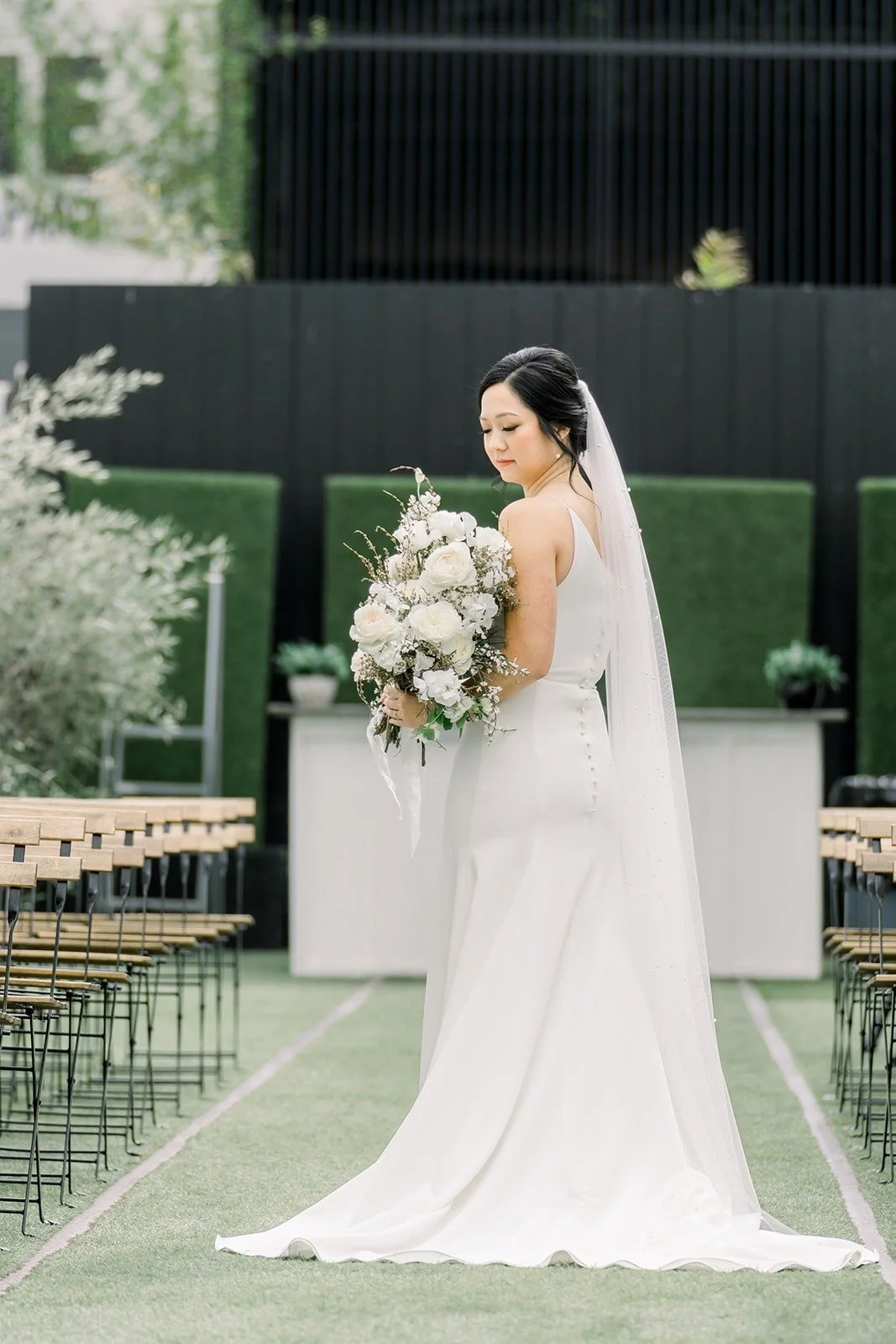 Cindy in her gown and long veil in the courtyard at The East Angel