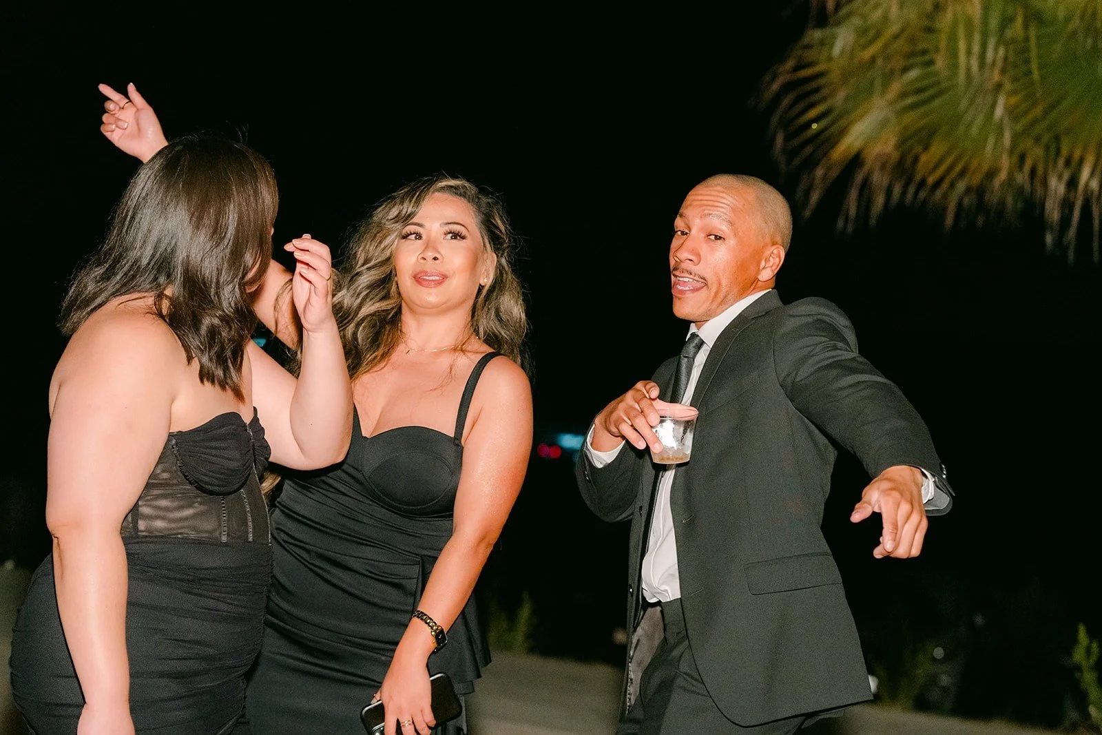 Guests dancing and singing along under the string lights