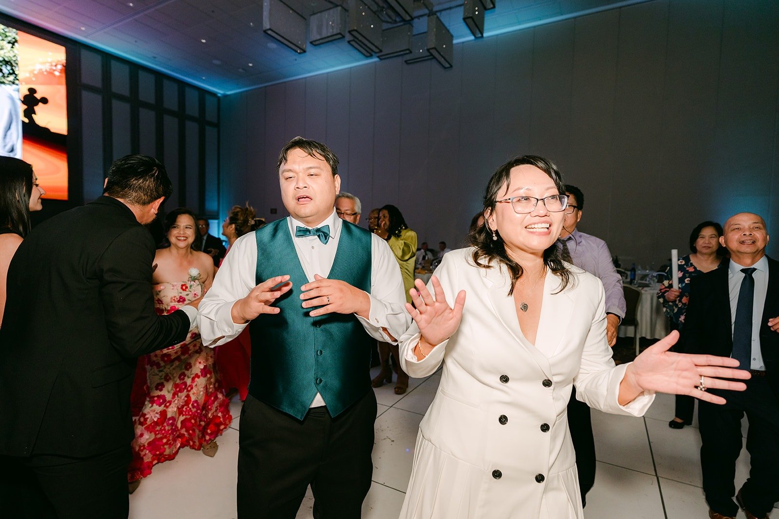 James in his teal vest dancing with Stella in a white suit jacket