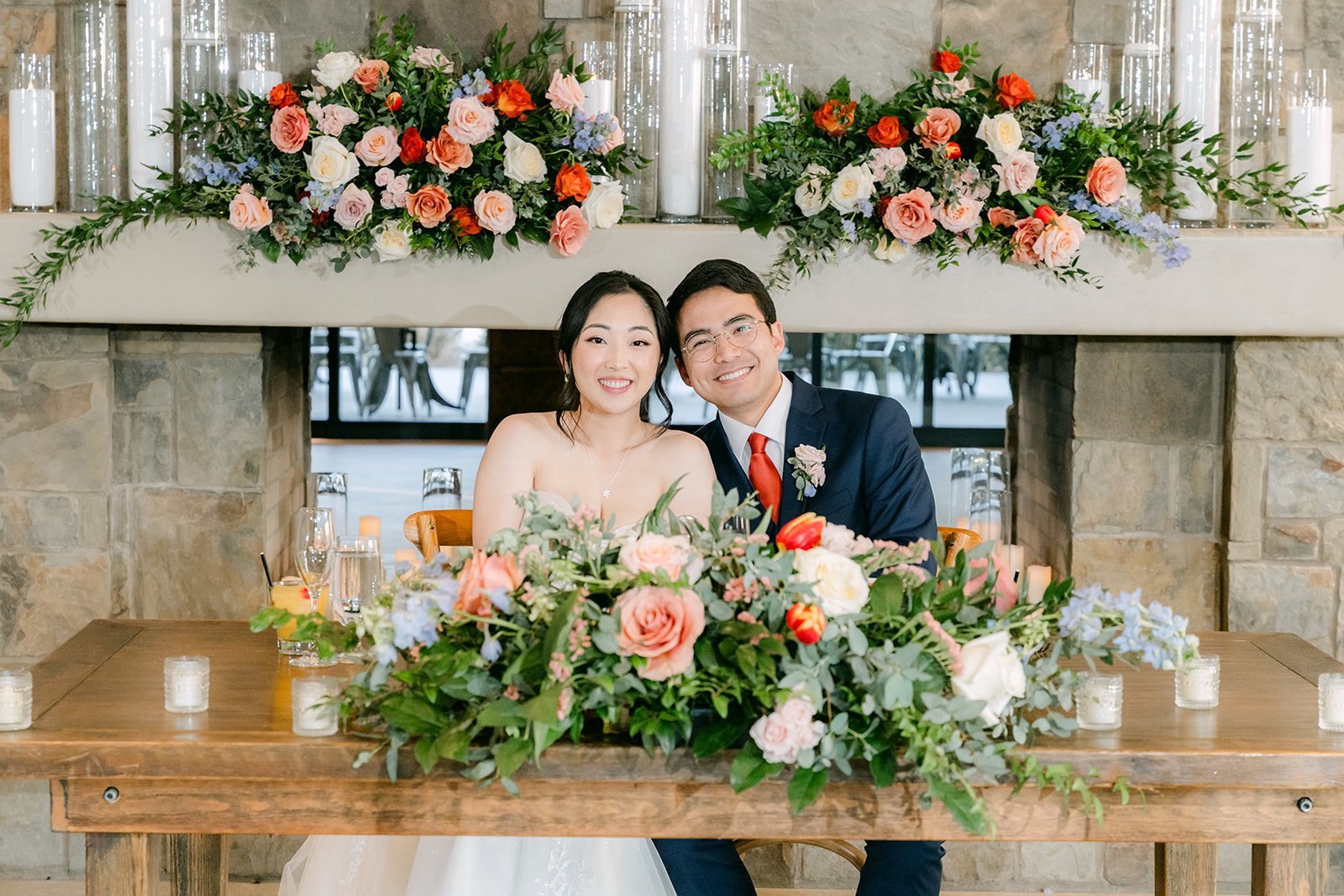 Couple at their sweetheart table framed by roses