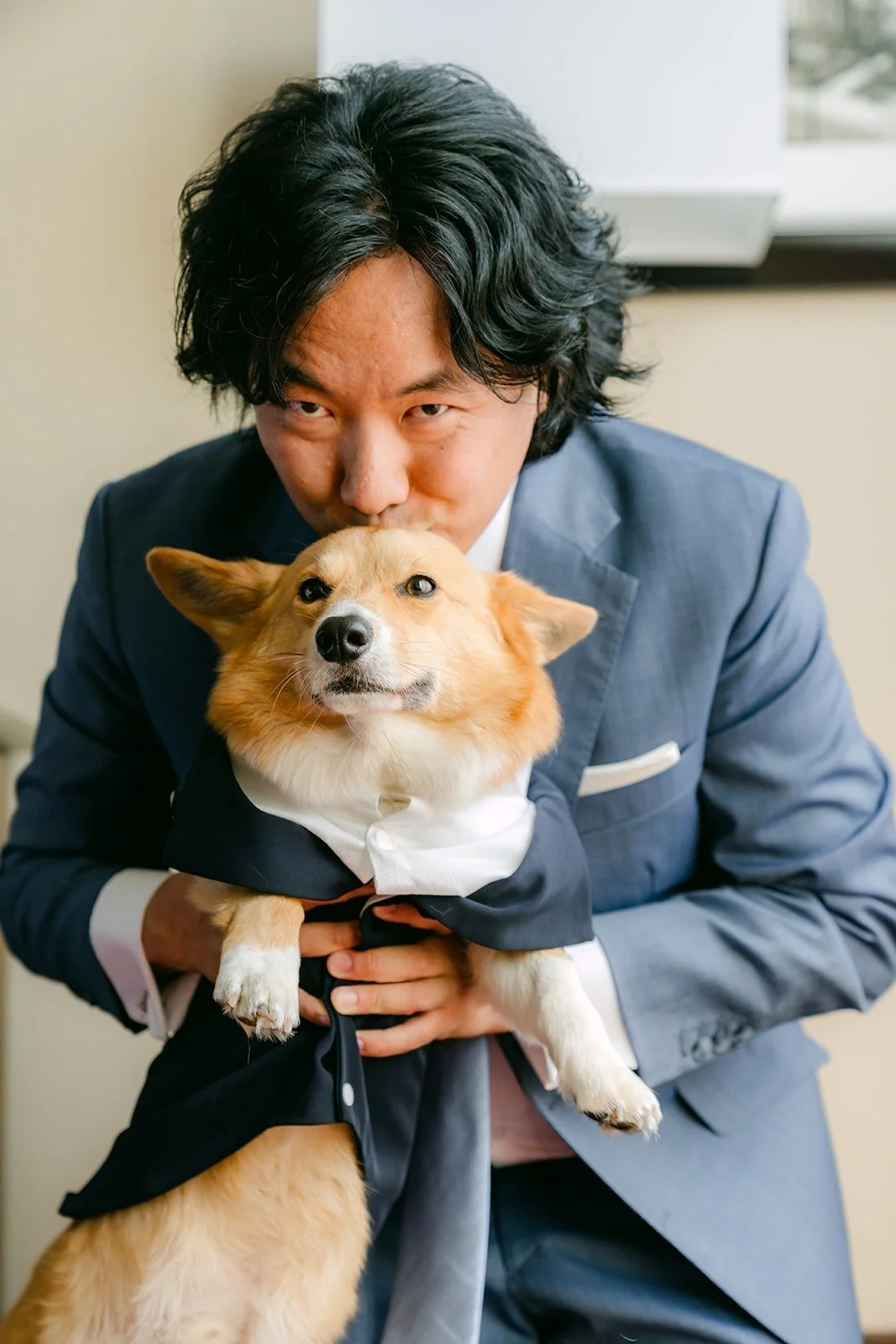 Philip holding the couple's corgi, dressed in a tiny tuxedo