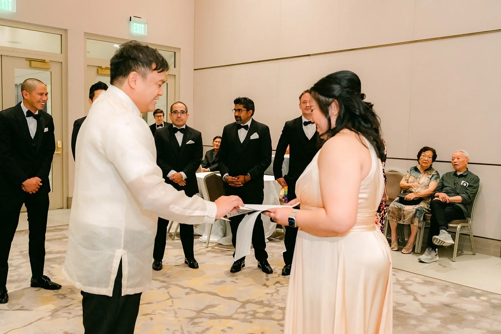 James answering a bridesmaid's question during the door games while the groomsmen look on