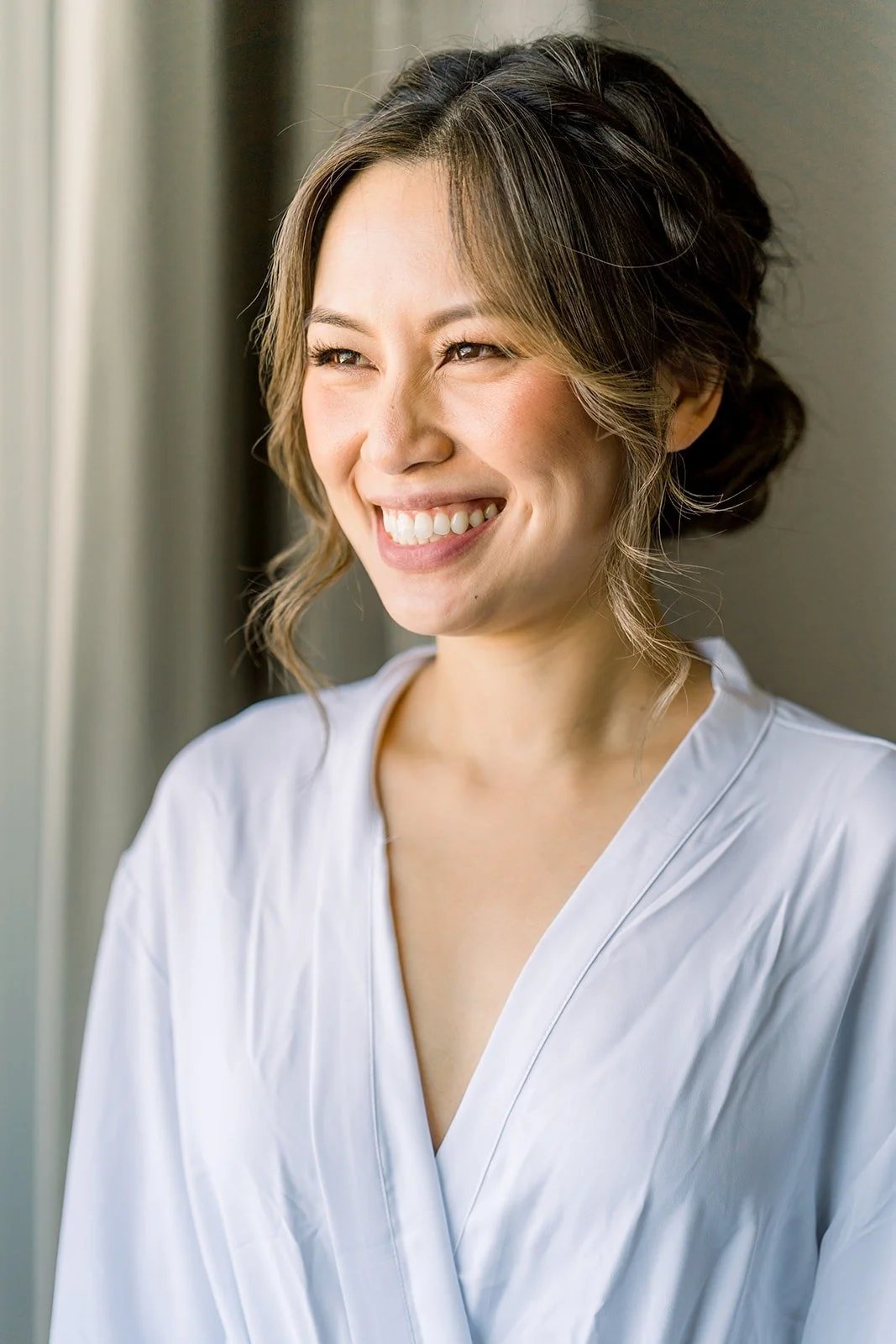 Josephine smiling by the window in a white robe