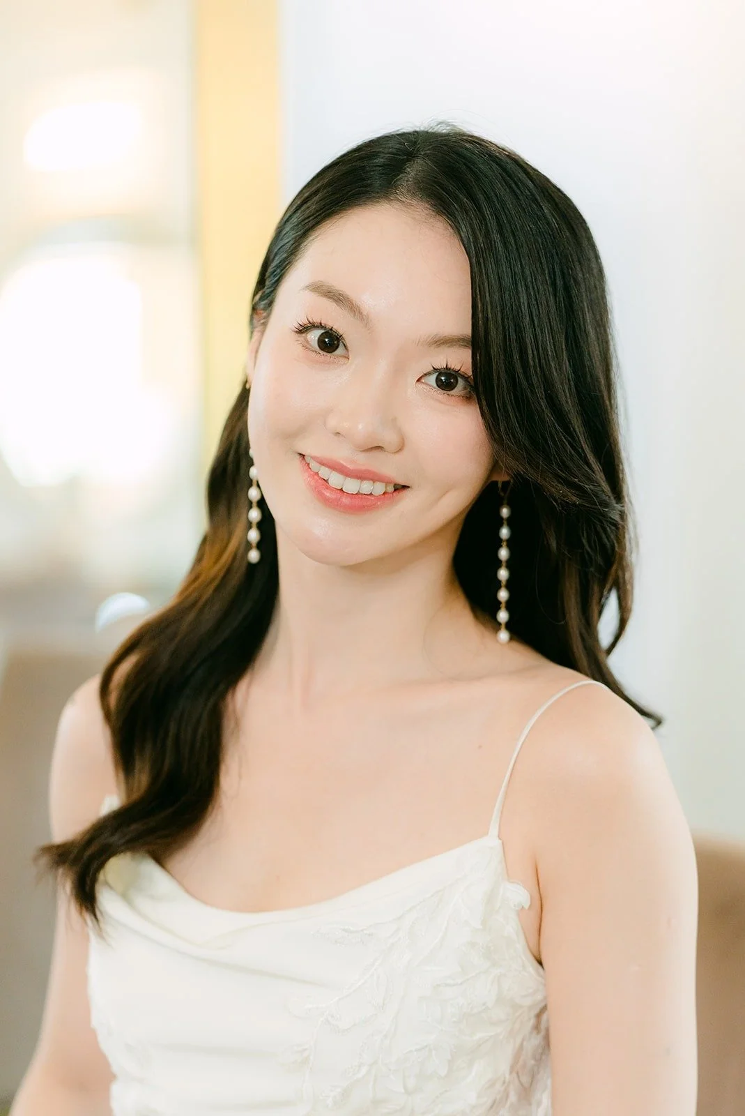 Tin smiling in her slip dress and long earrings