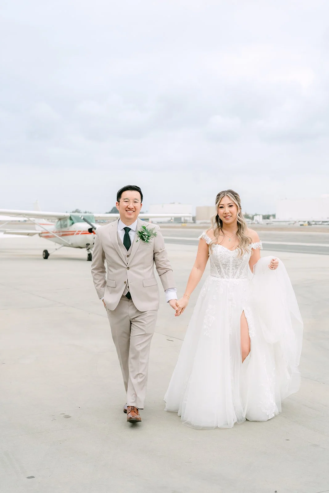 Bride and groom strolling across the tarmac near The Modern