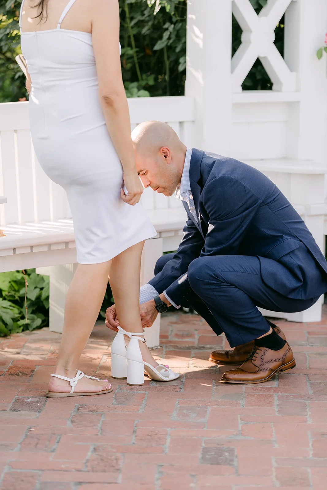 Daniel crouches at Francesca's feet beside the gazebo.