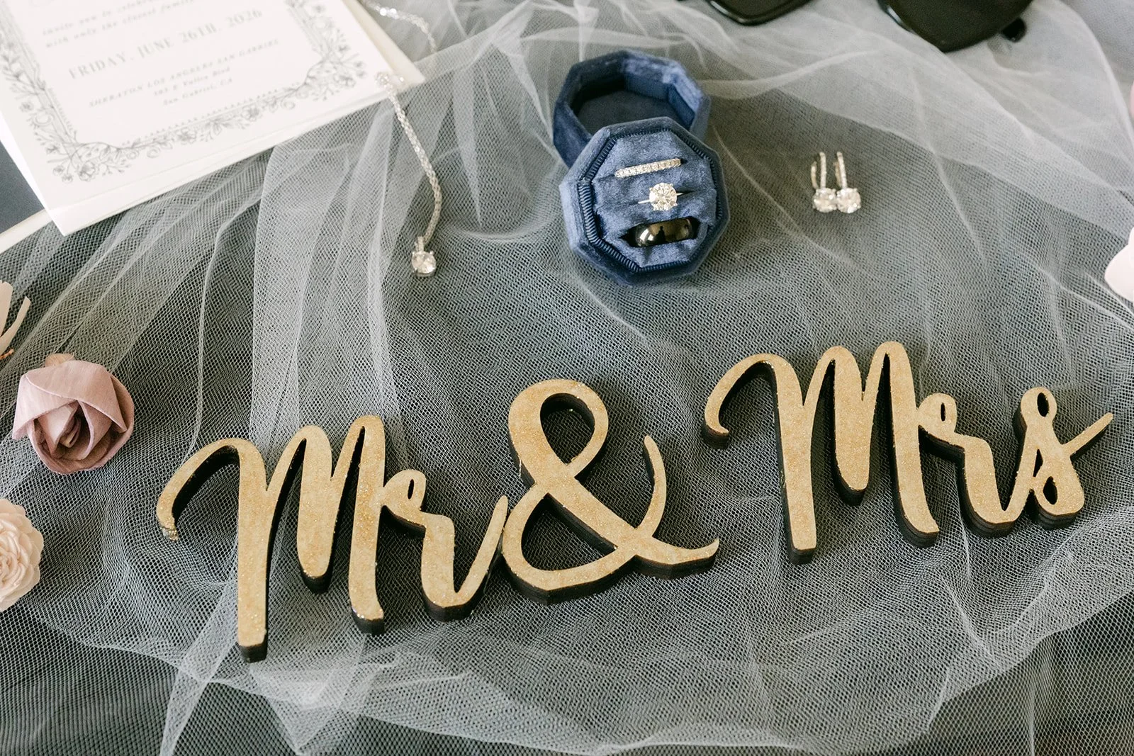 Gold Mr and Mrs sign with lavender and navy flowers on tulle.
