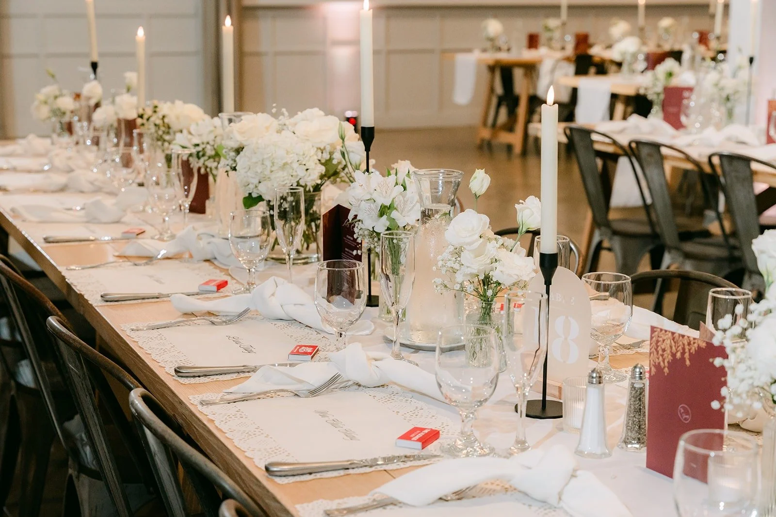 Long reception tables with white linens and burgundy menus