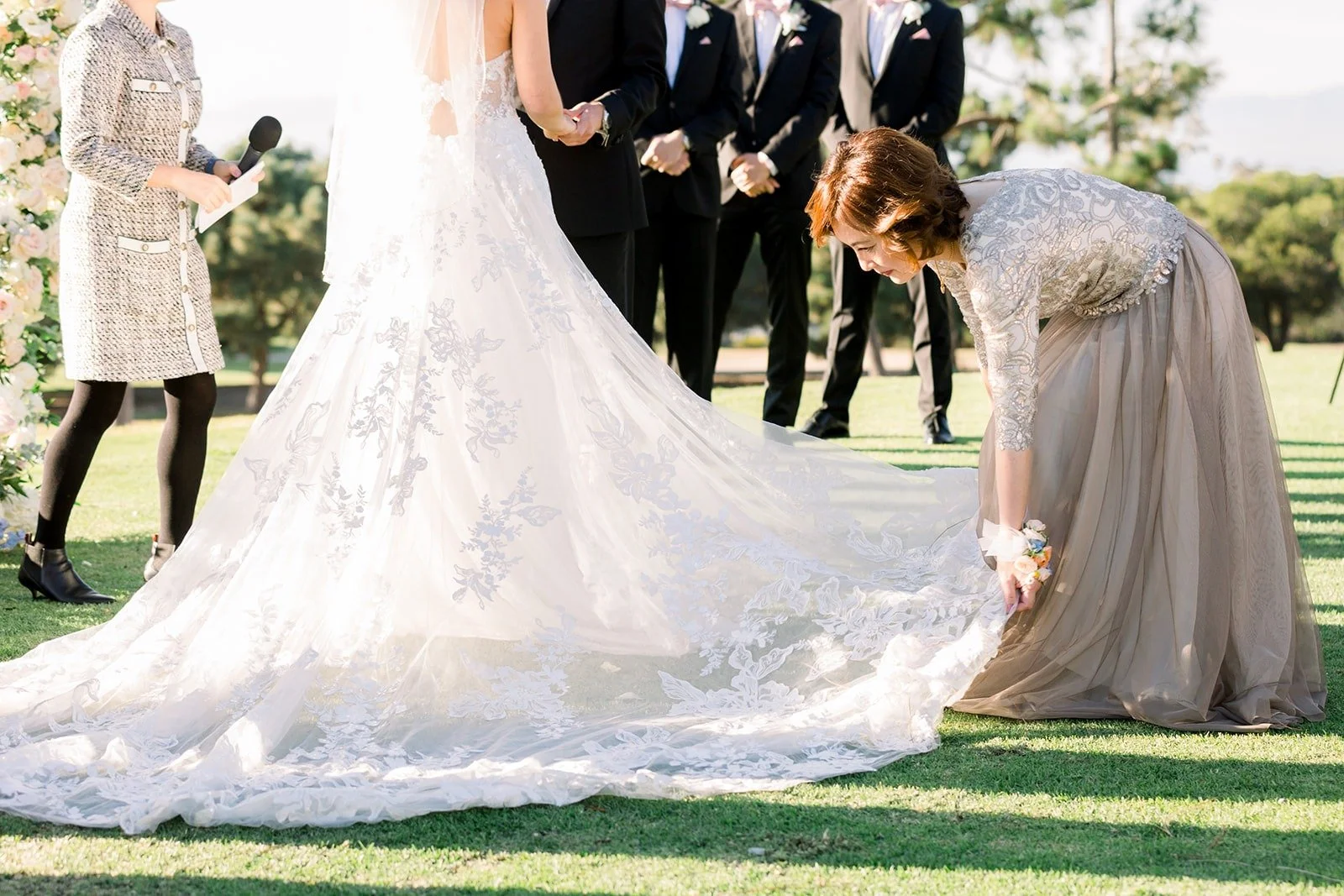 A bridesmaid fixing Josephine's train at the arch