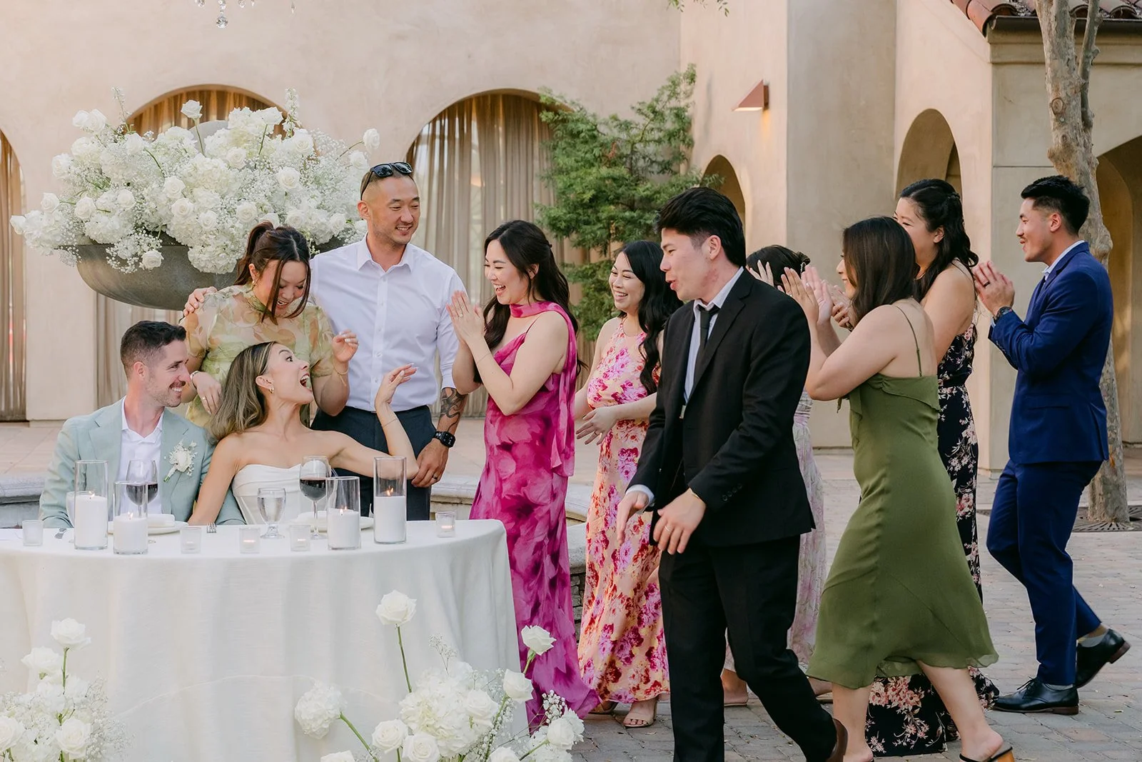 Friends crowding around the table for a photo with the couple