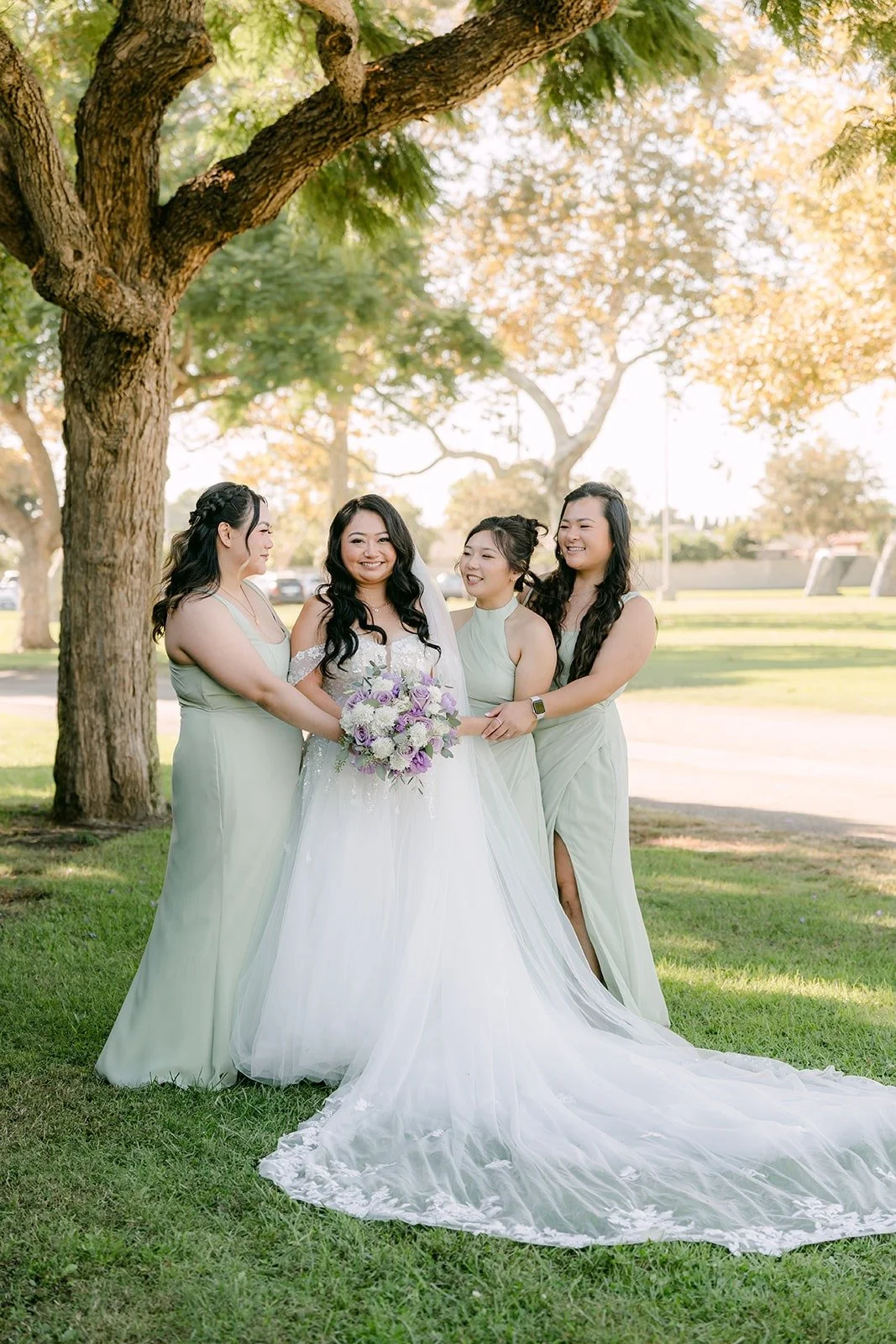 Jennifer with her bridesmaids under a tree at Garden Grove Park