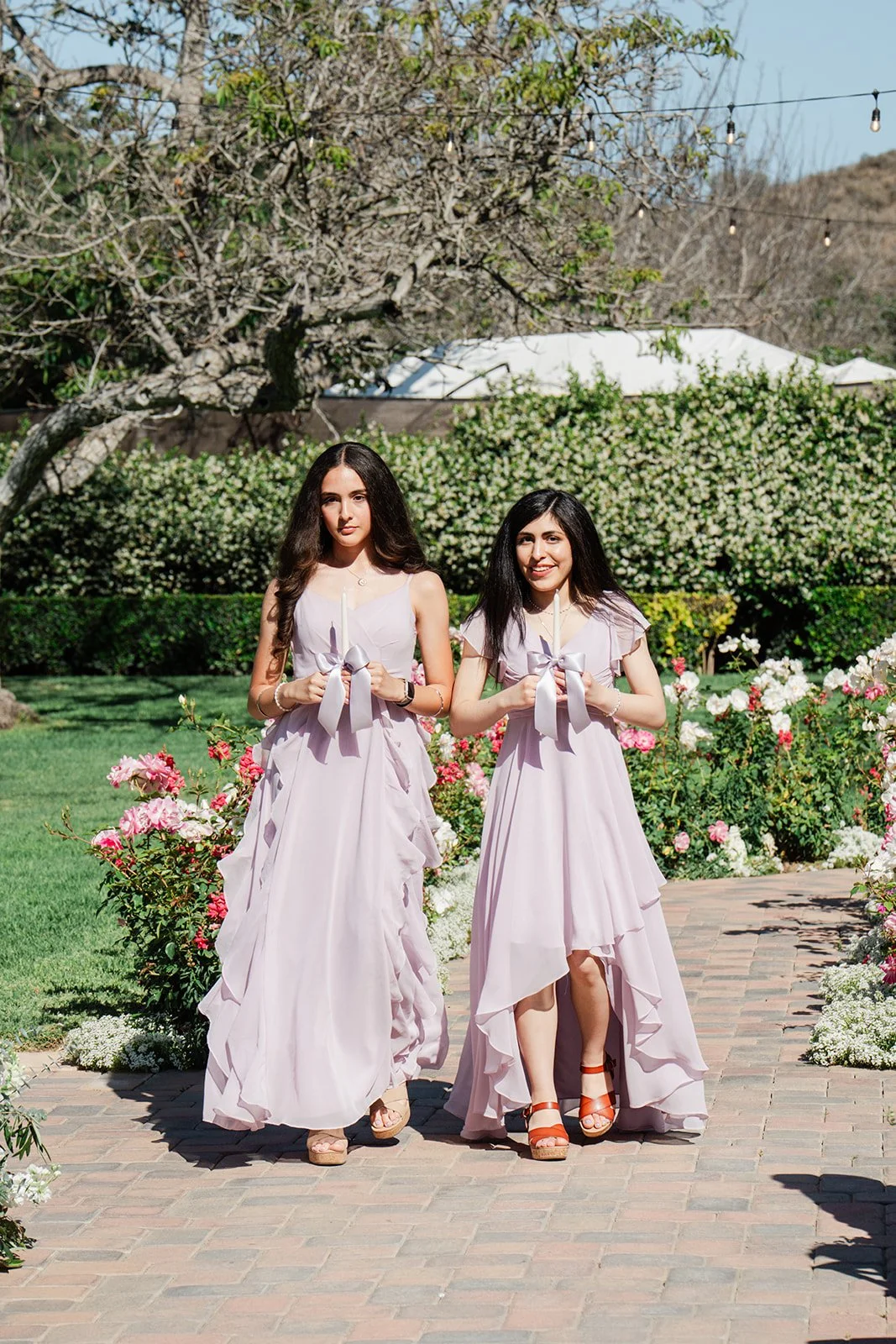 Bridesmaids in lavender dresses walking down the aisle