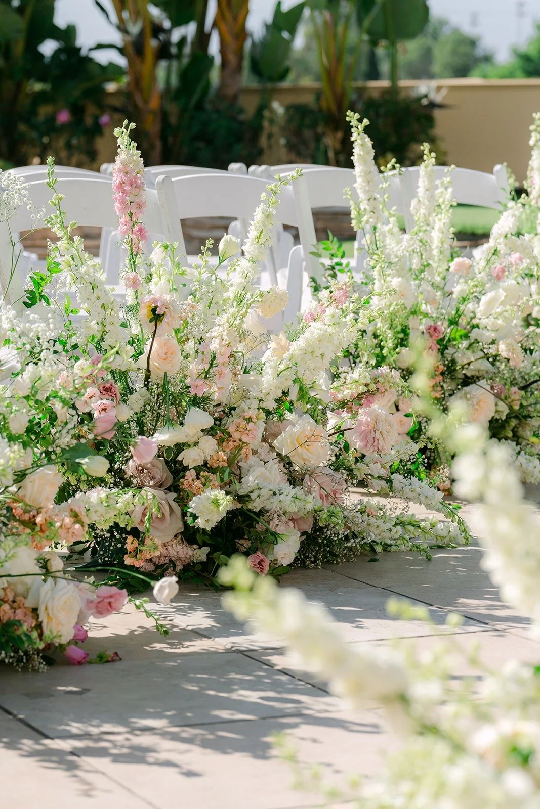 Blush and white florals lining the ceremony aisle