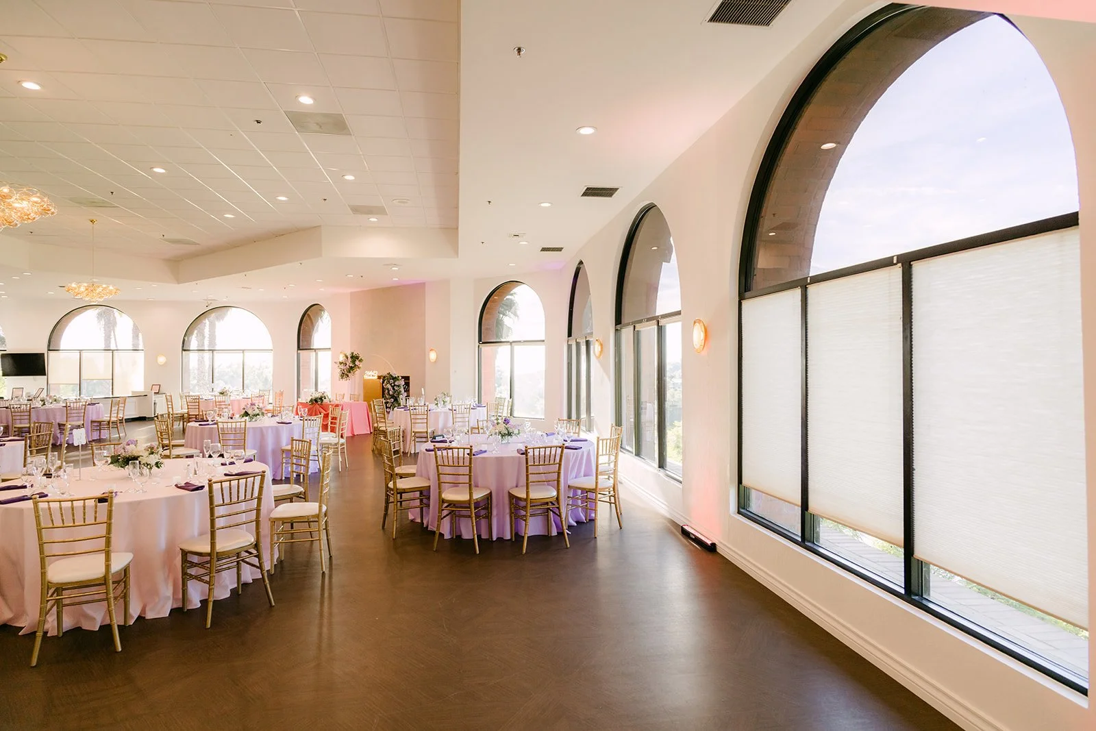The reception room set with blush linens and lilac florals.