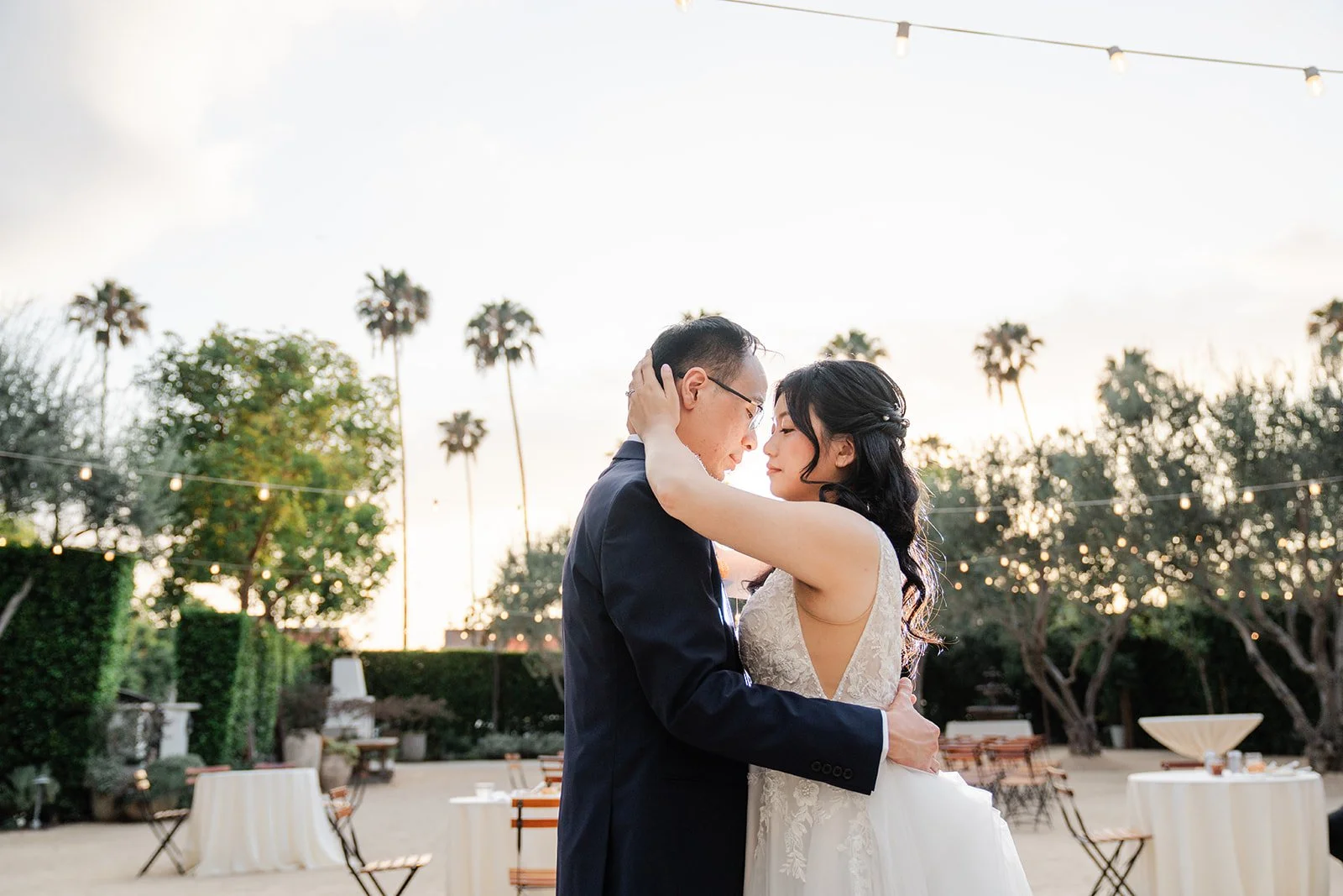Couple embracing at sunset with palm trees on the skyline