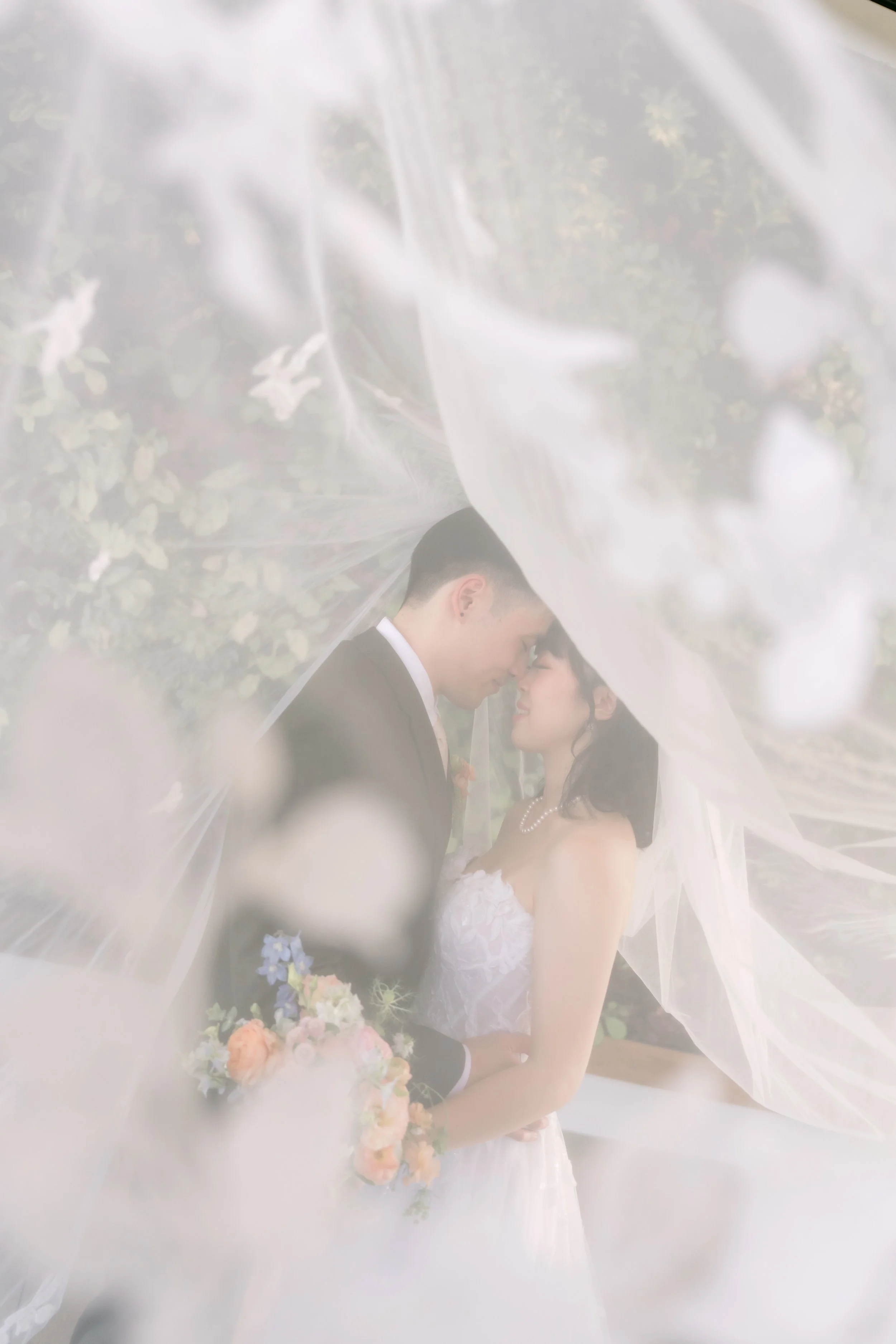 Vivian and Alex sharing a kiss through her veil at The Colony House in Anaheim