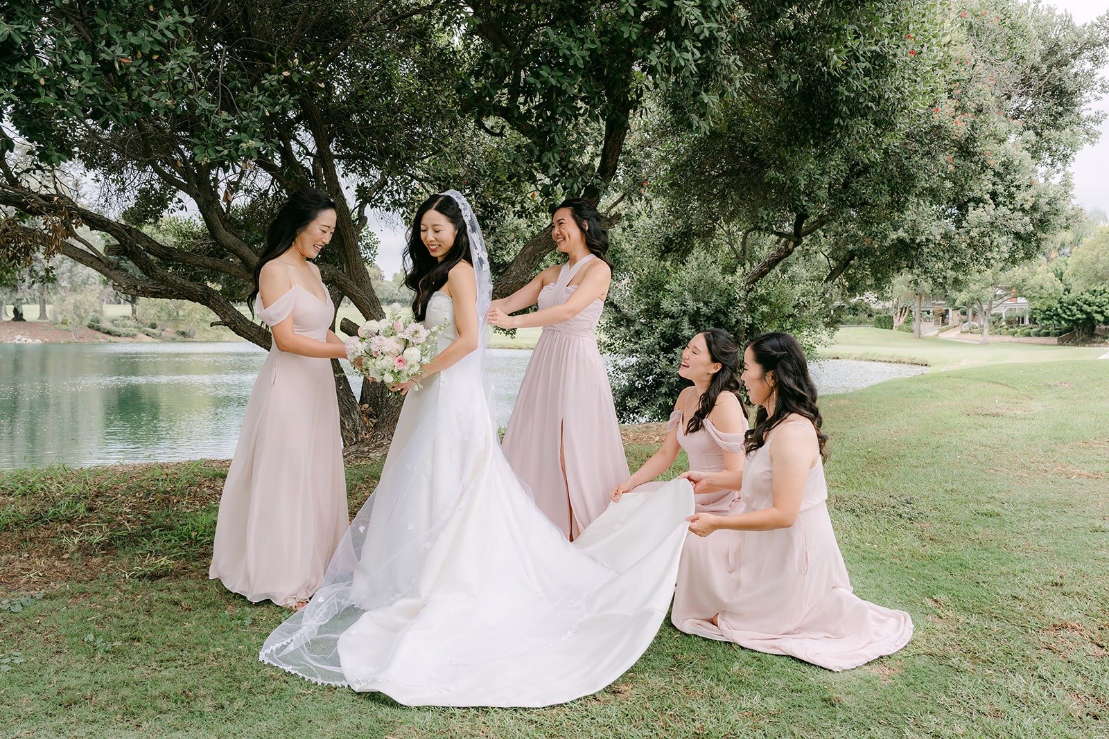 Kristine and her bridesmaids in dusty pink gowns gathered by the lake