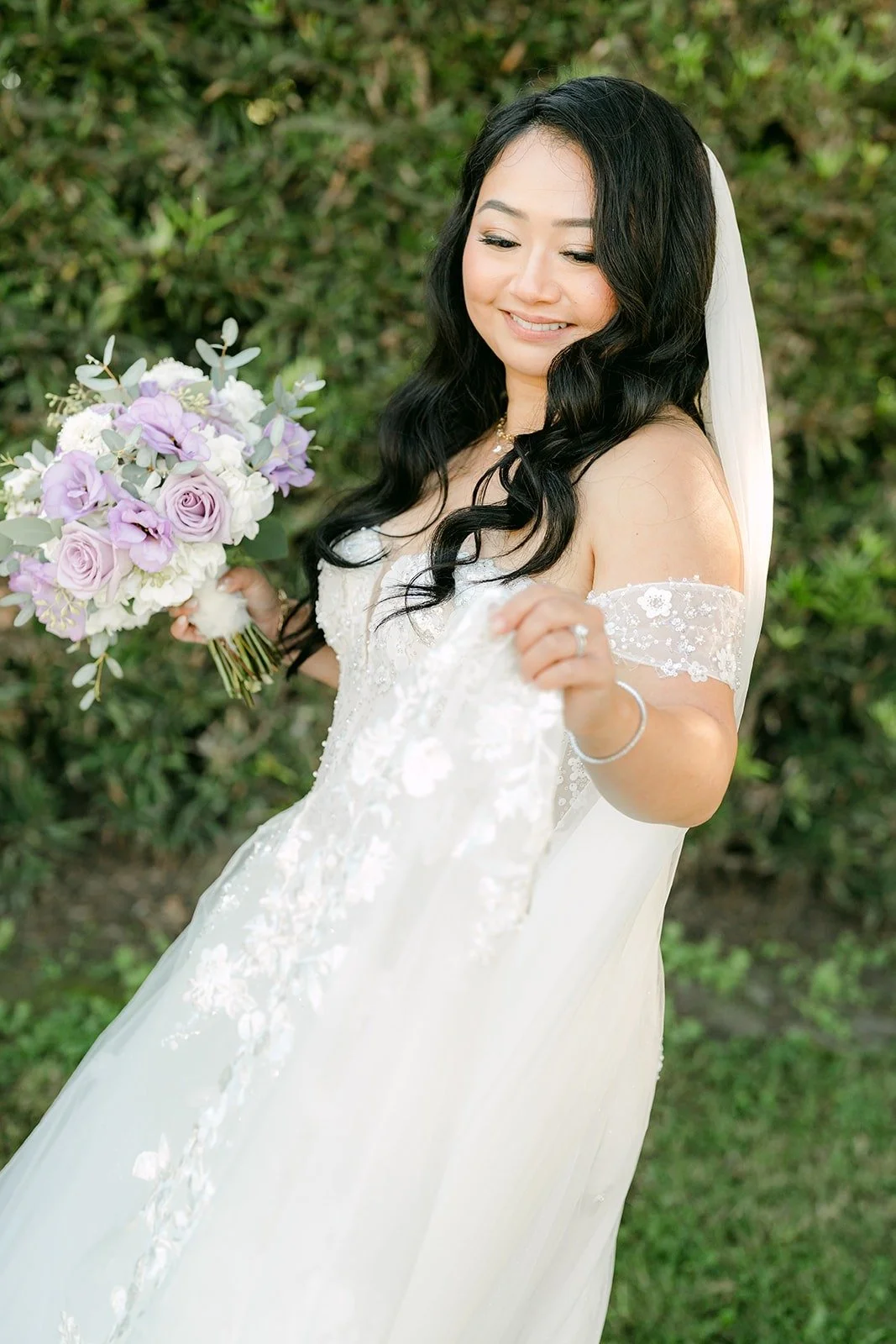 Jennifer laughs as she holds her lavender and white bouquet