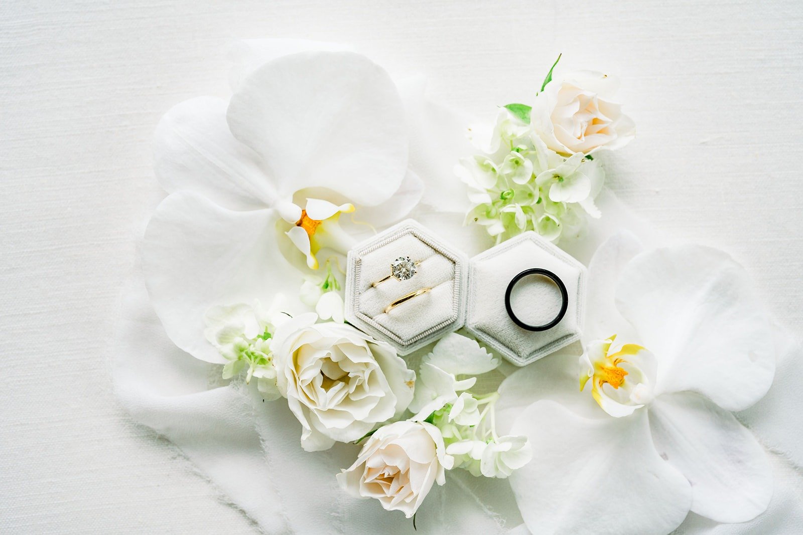Wedding rings nestled among white orchids