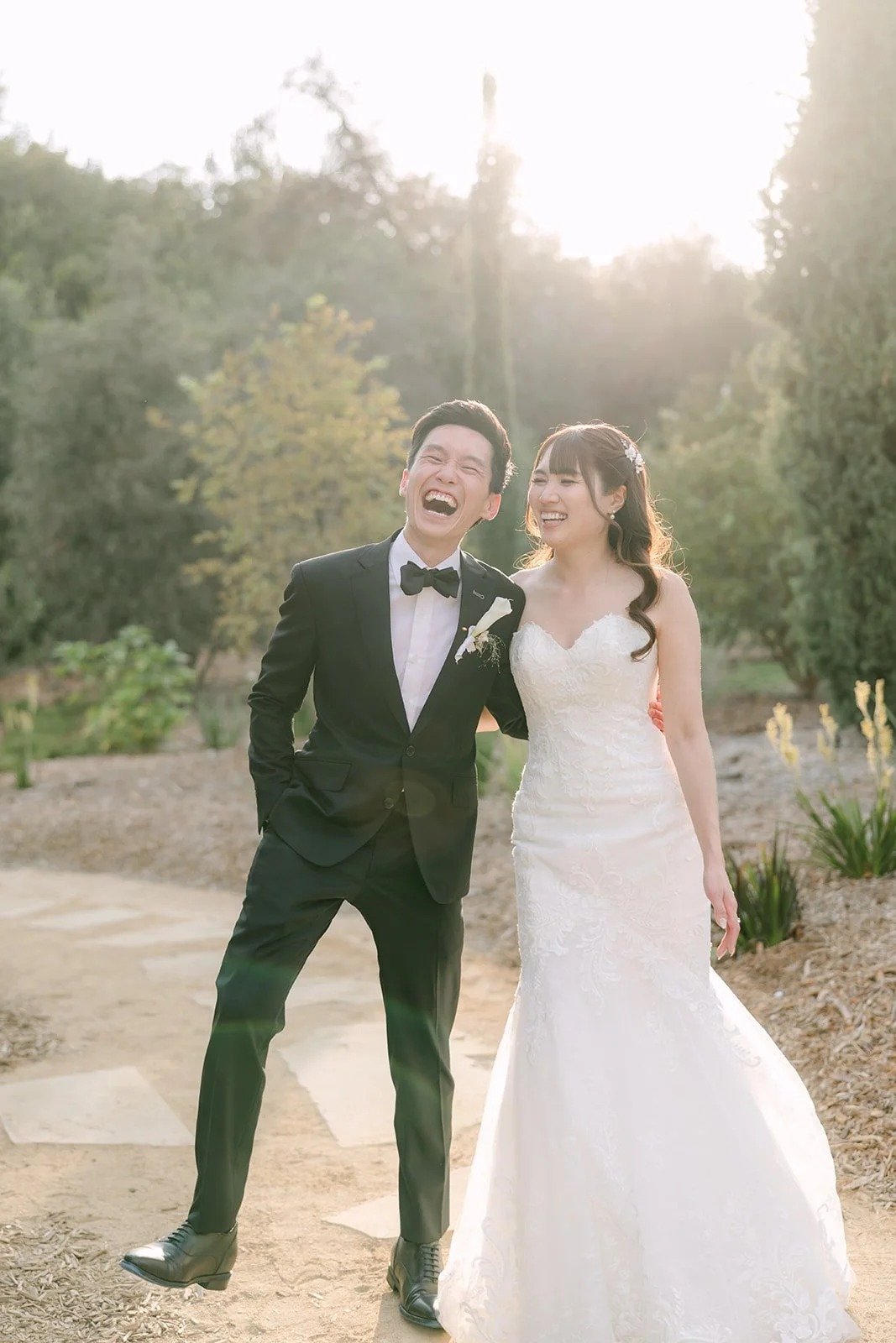 Marina and Tyler laughing together in the cypress garden at golden hour