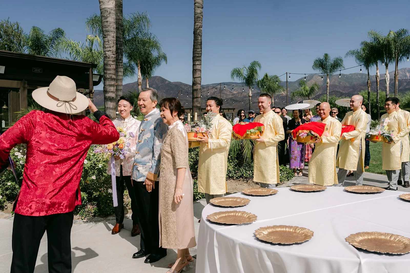 Family members lining up in the courtyard with red gift trays for the procession.