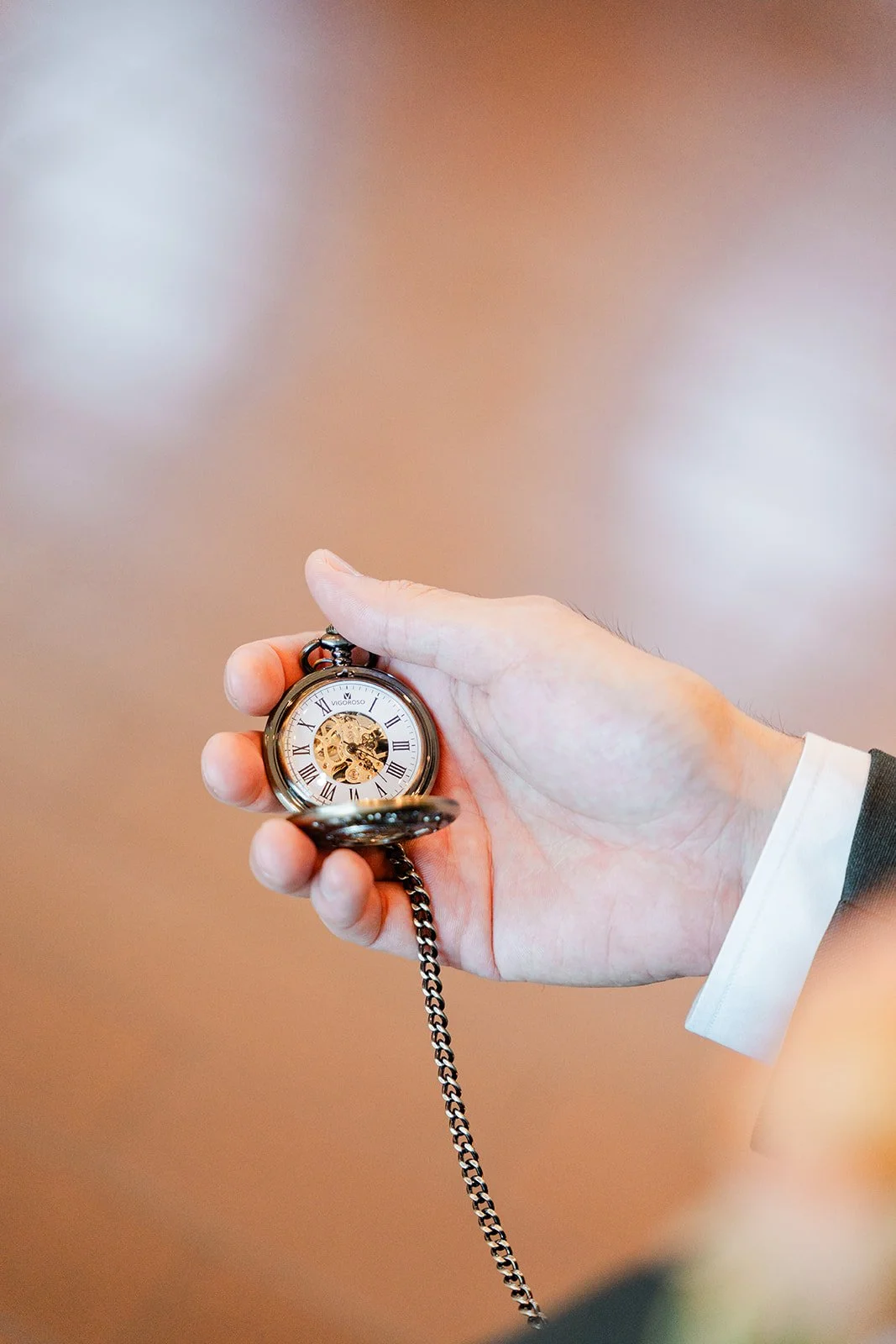 Close up of Alex holding a vintage pocket watch, photographed by One and Only Production