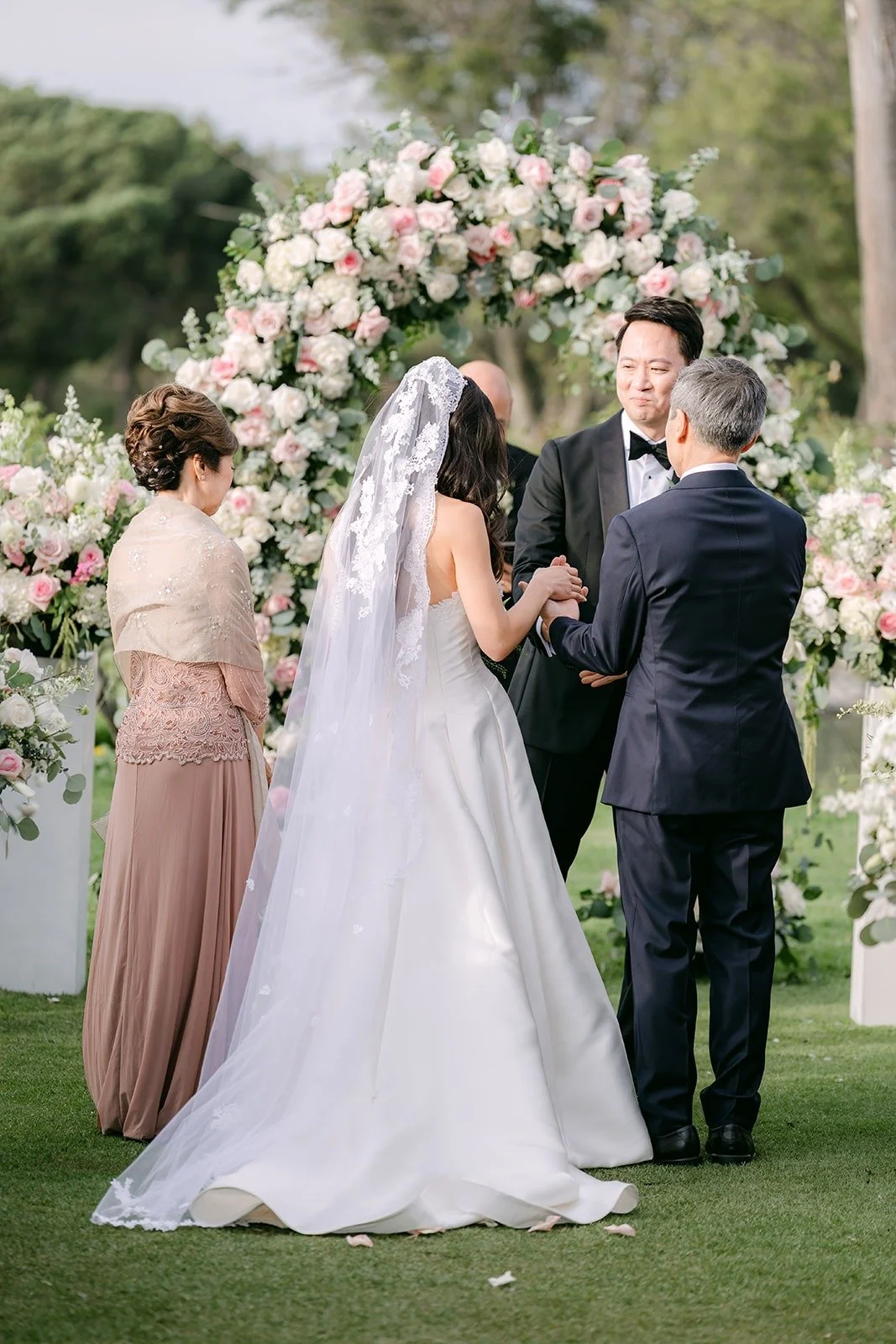Kristine and William standing at the floral arch with their officiant