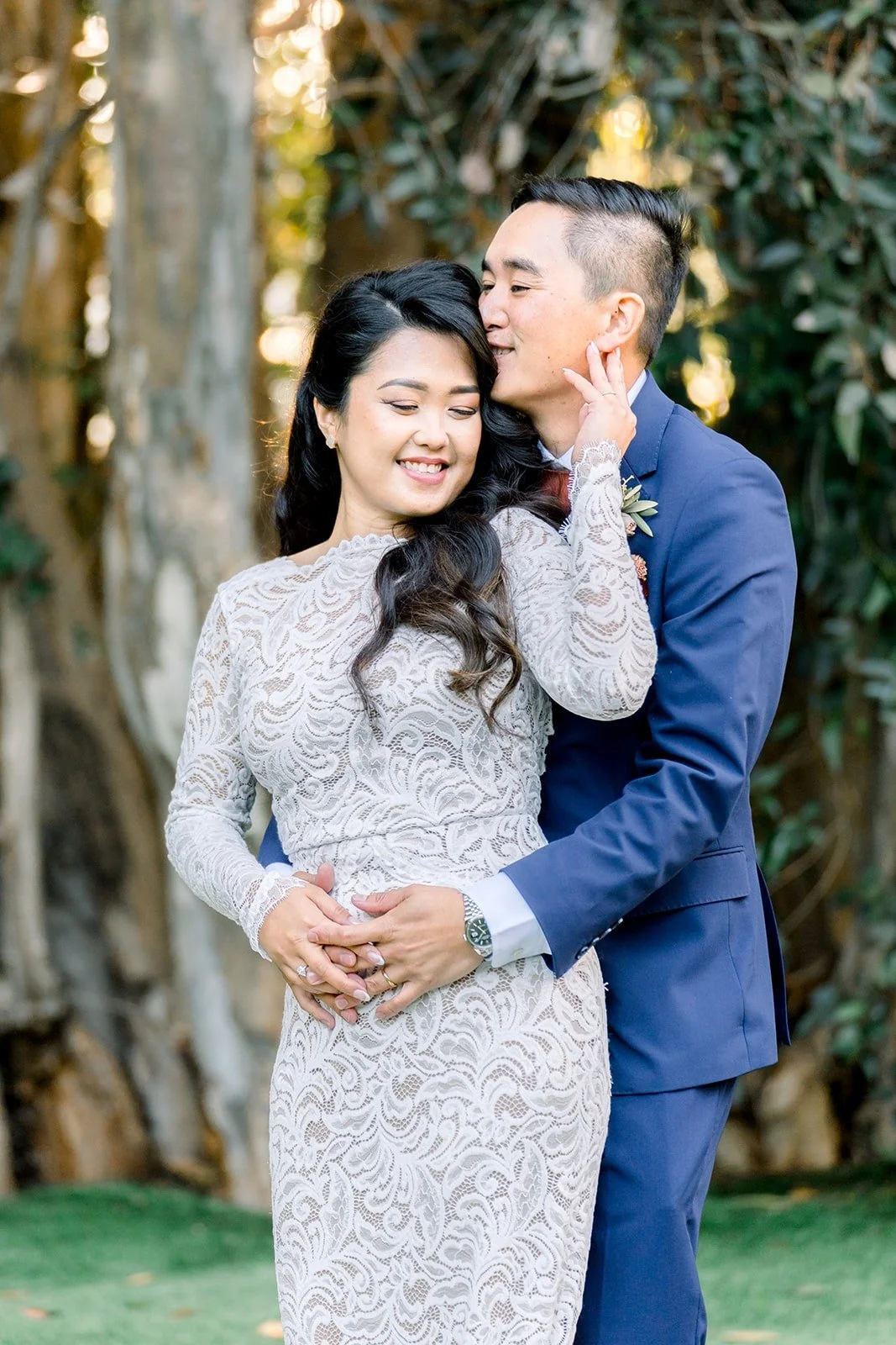 Vincent holding Hannah close in front of a eucalyptus trunk