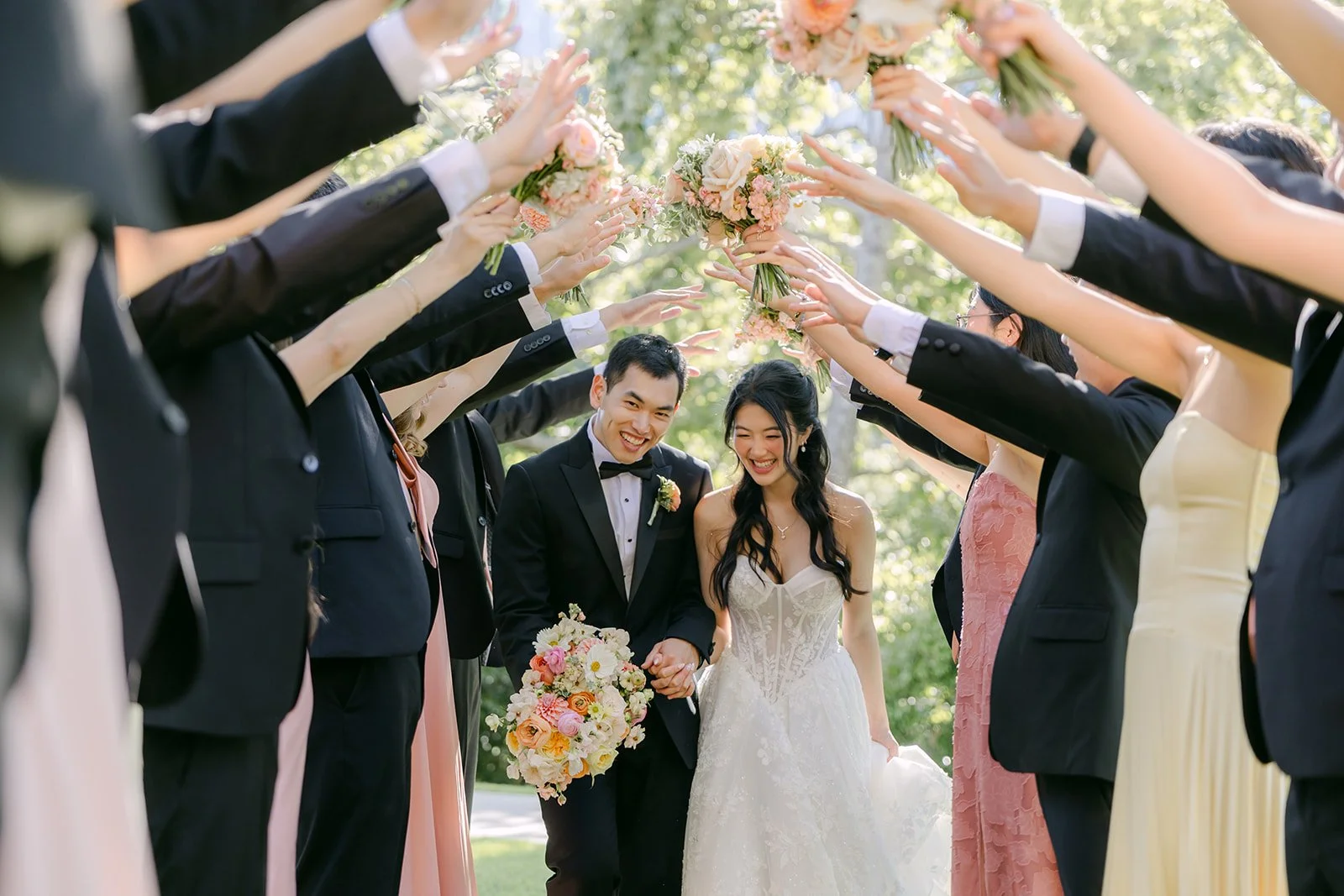 Groomsmen raising their arms over Clarissa and Austin