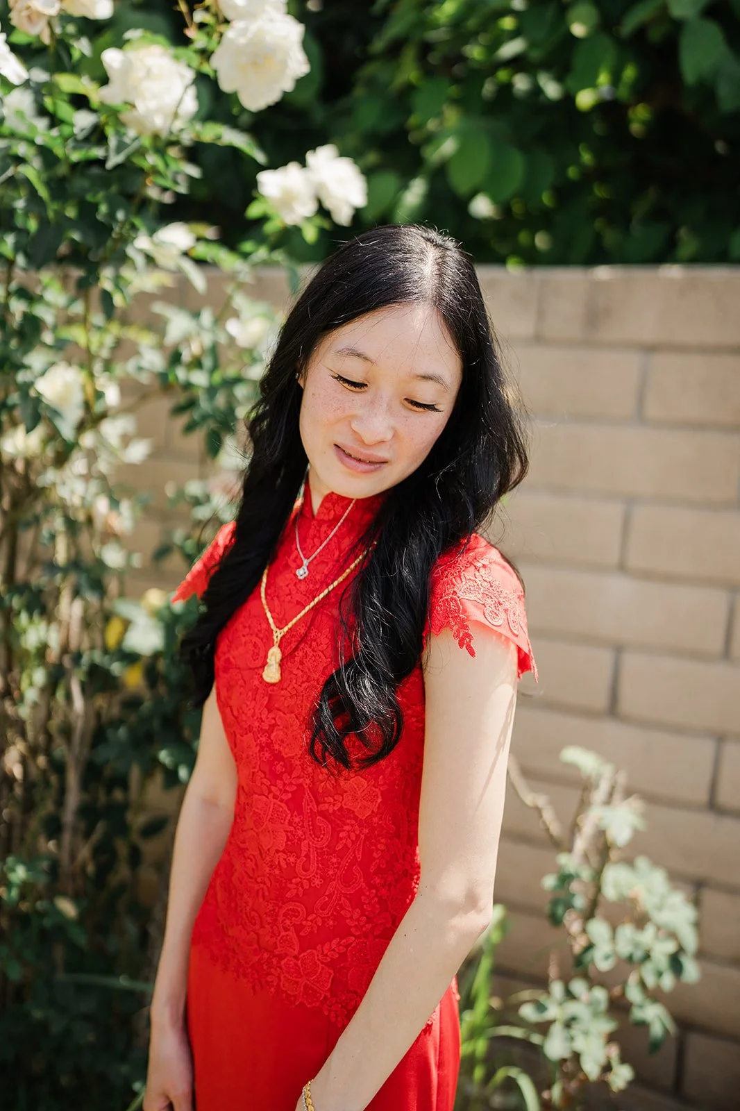 Valerie in her red qipao among white roses.