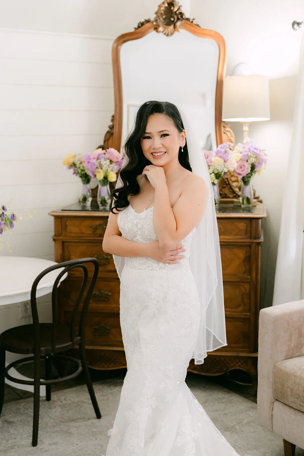 Vannie in her gown in front of a gold mirror.