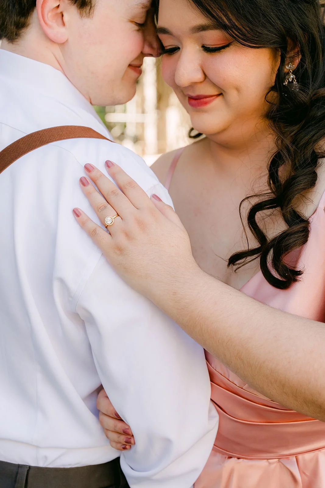 Saira resting her hand on Matthew's chest, her engagement ring catching the light.