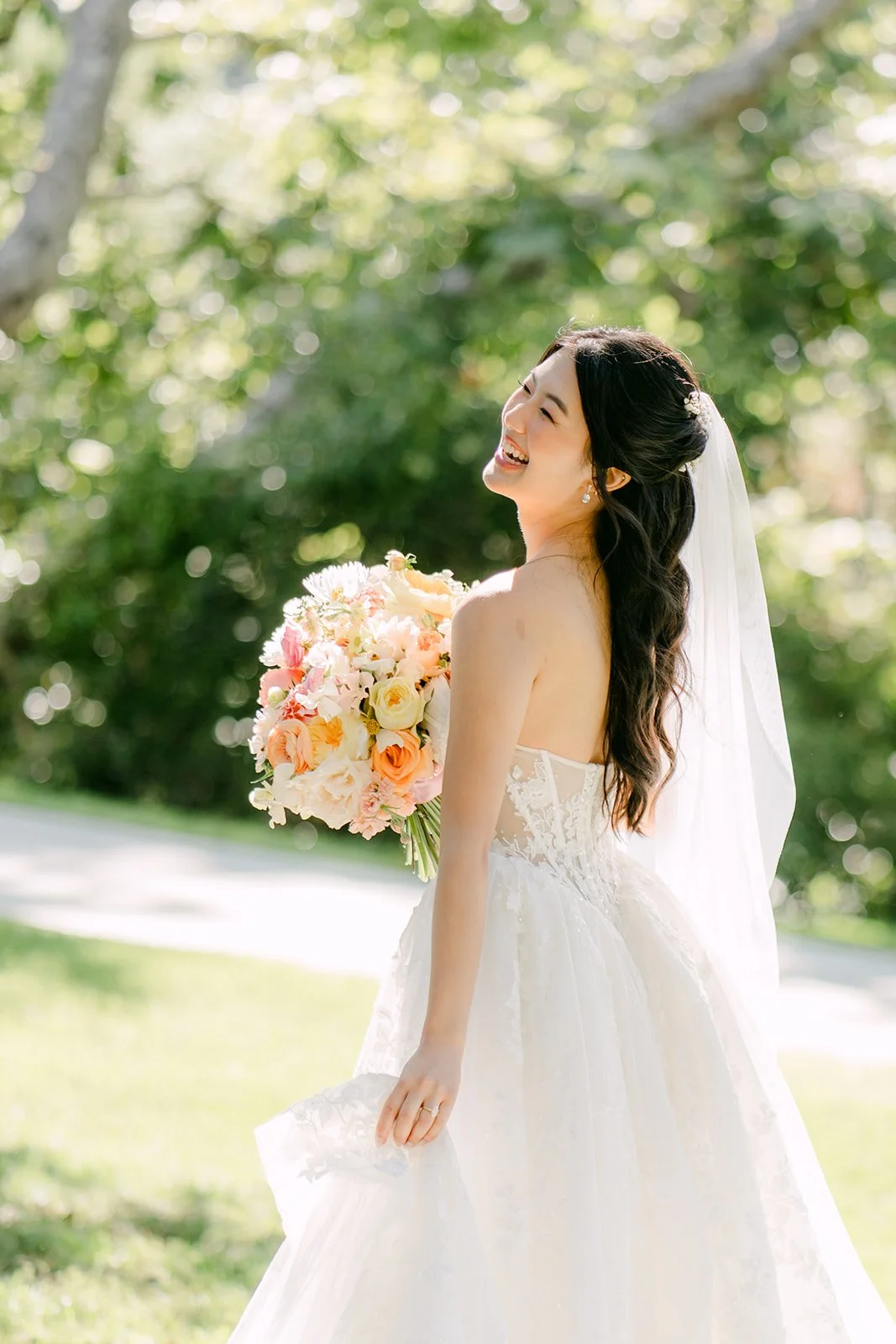 Clarissa walking across the lawn with her bouquet
