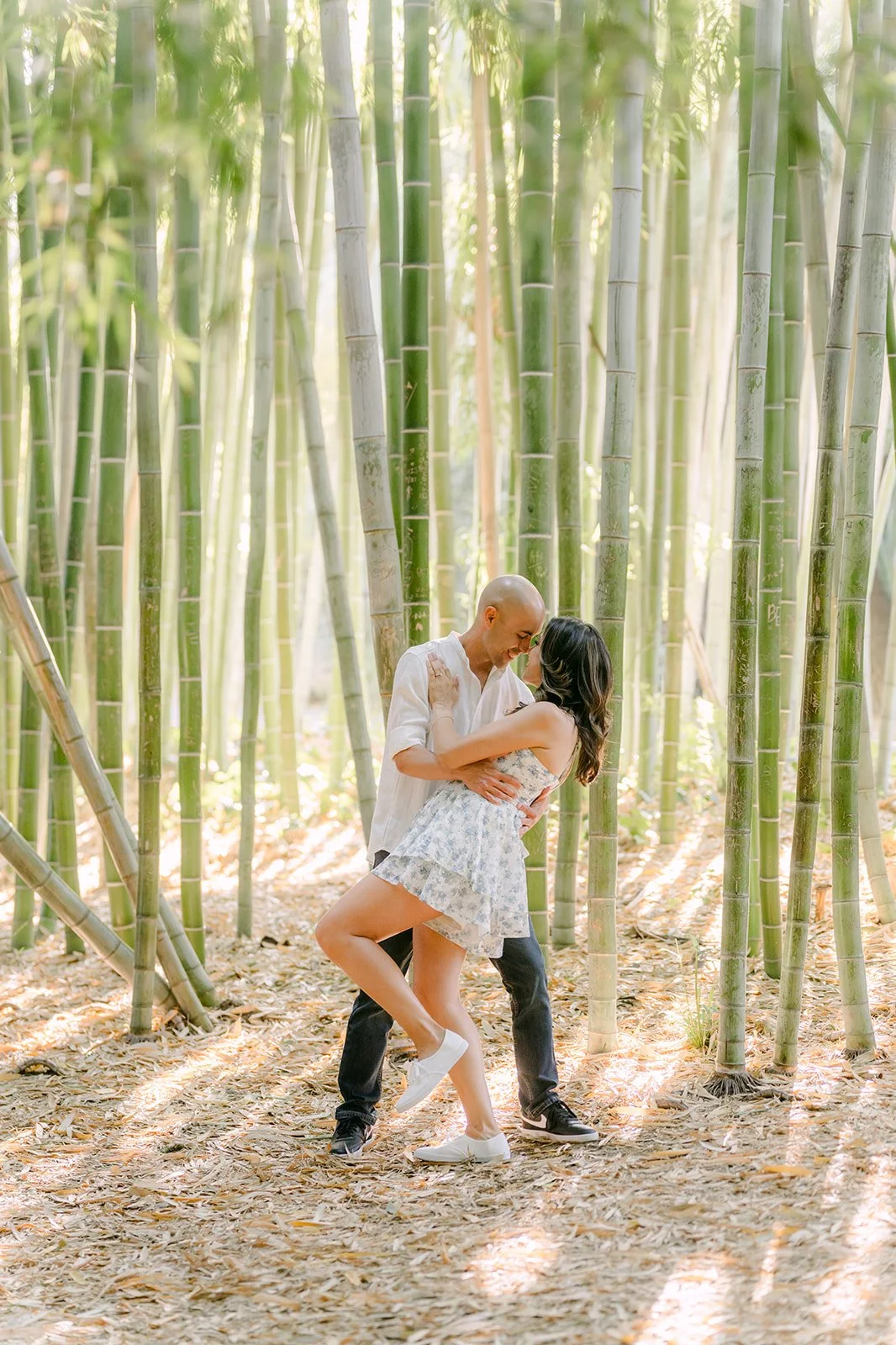 Daniel lifts Francesca off her feet in the bamboo grove.
