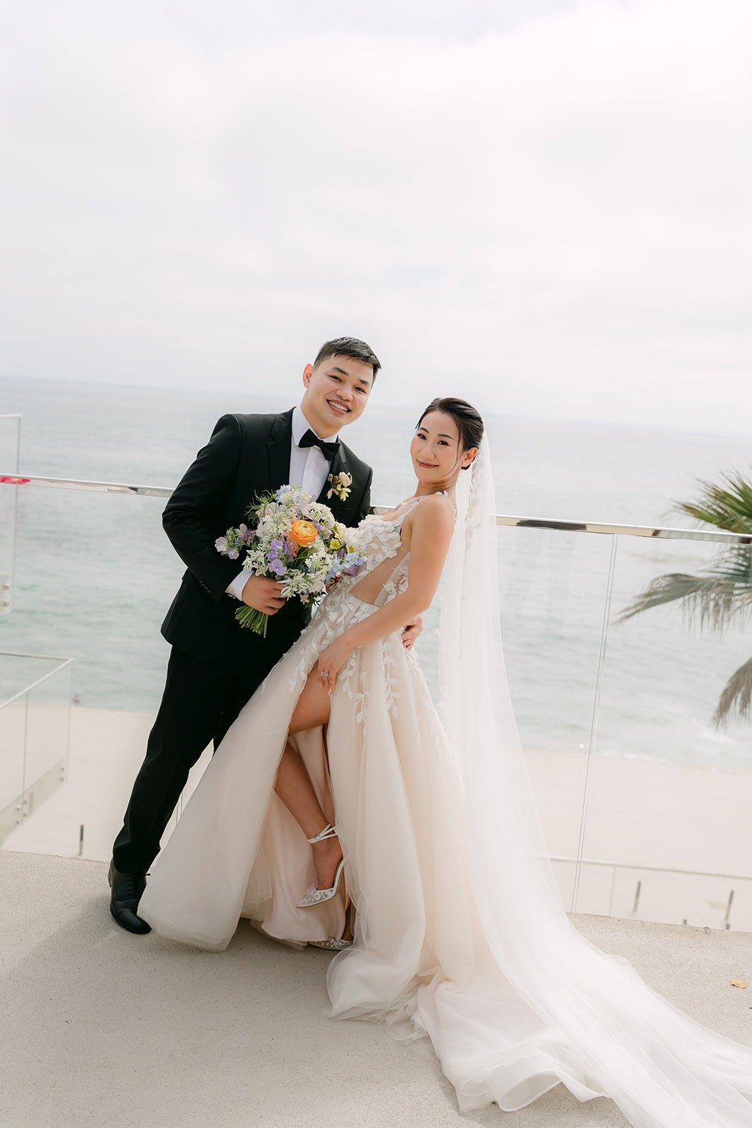 Kylie and Mario laughing by the terrace railing in the breeze