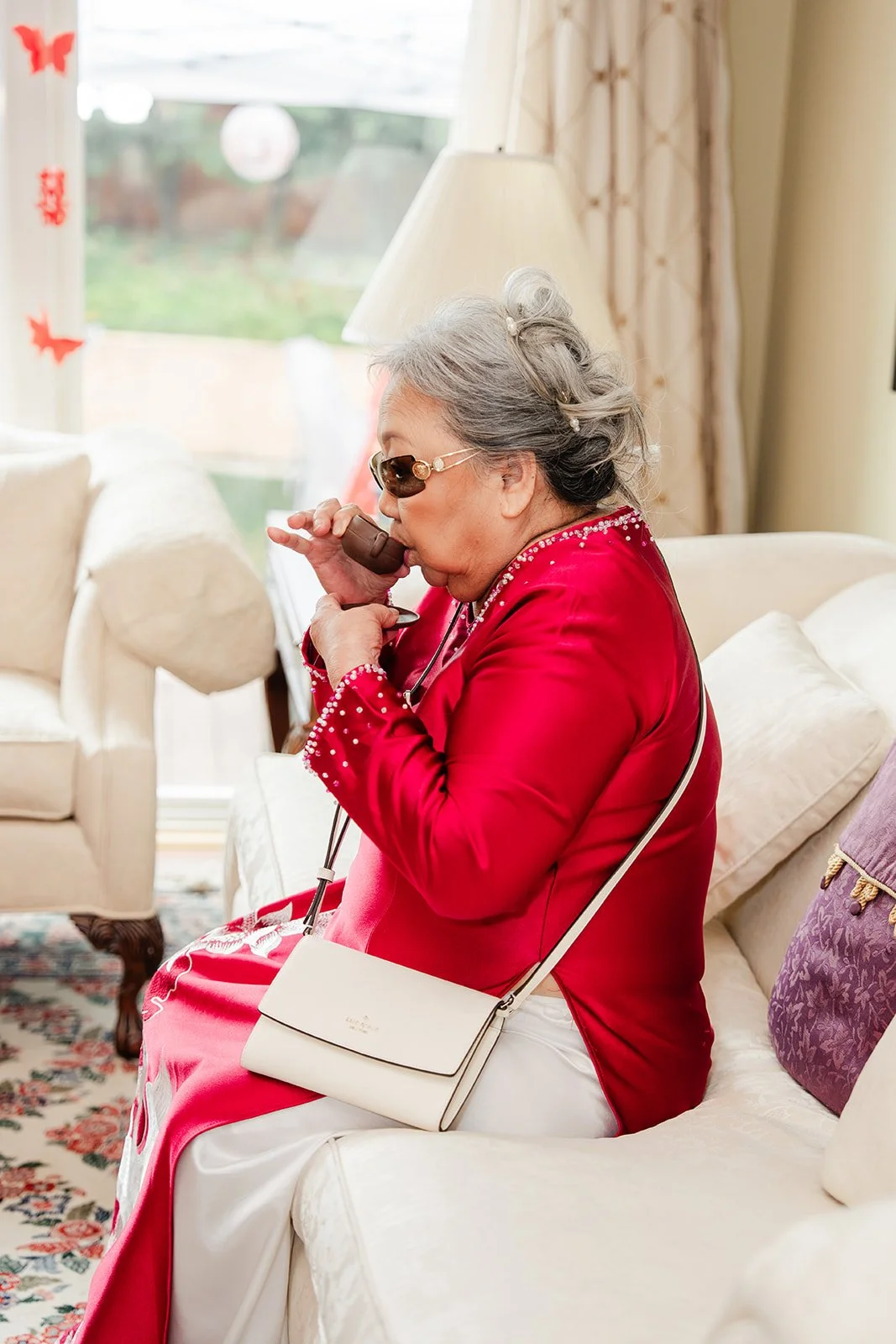 A grandmother sipping tea served by the couple.