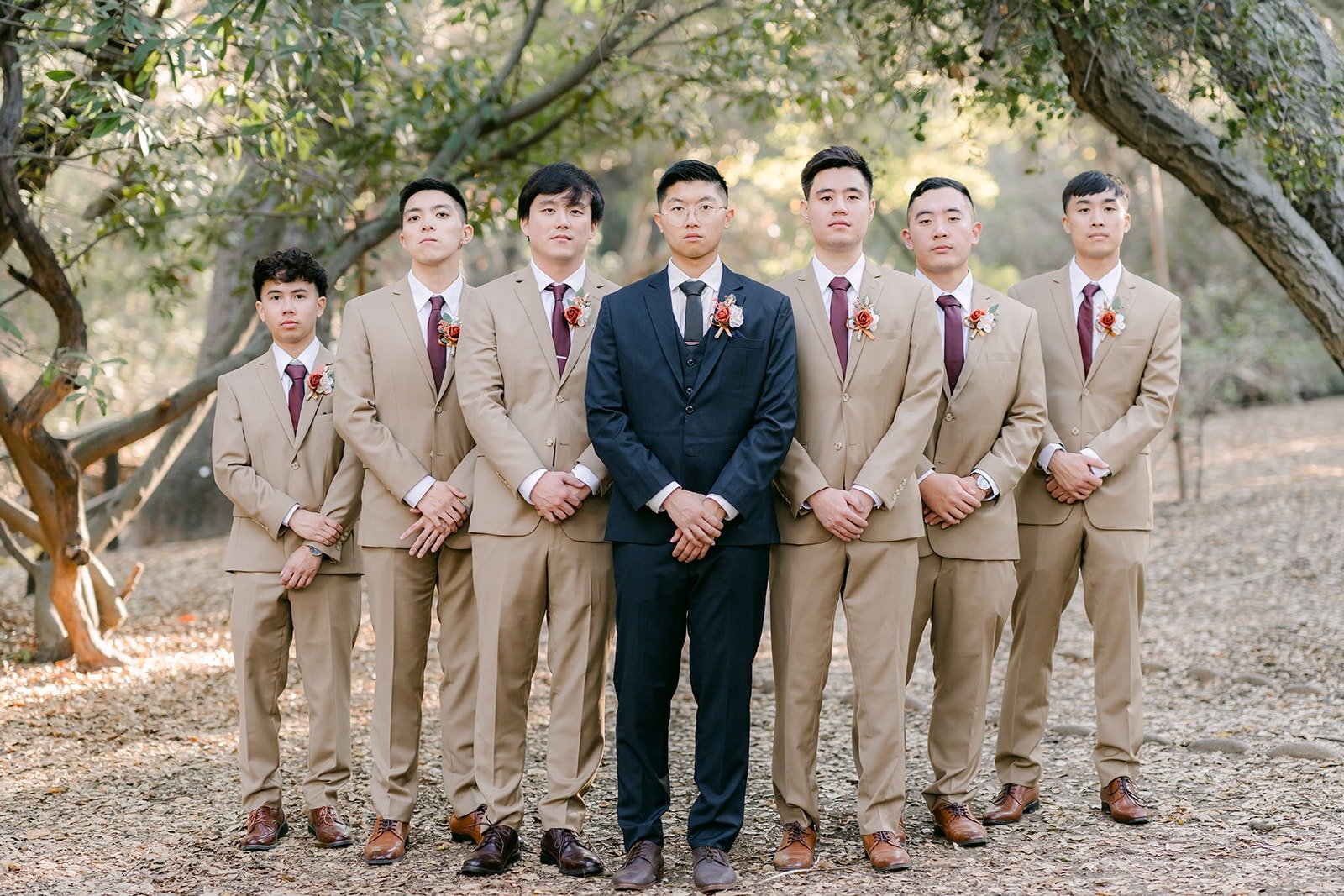 Robert with his groomsmen in tan suits under the oaks
